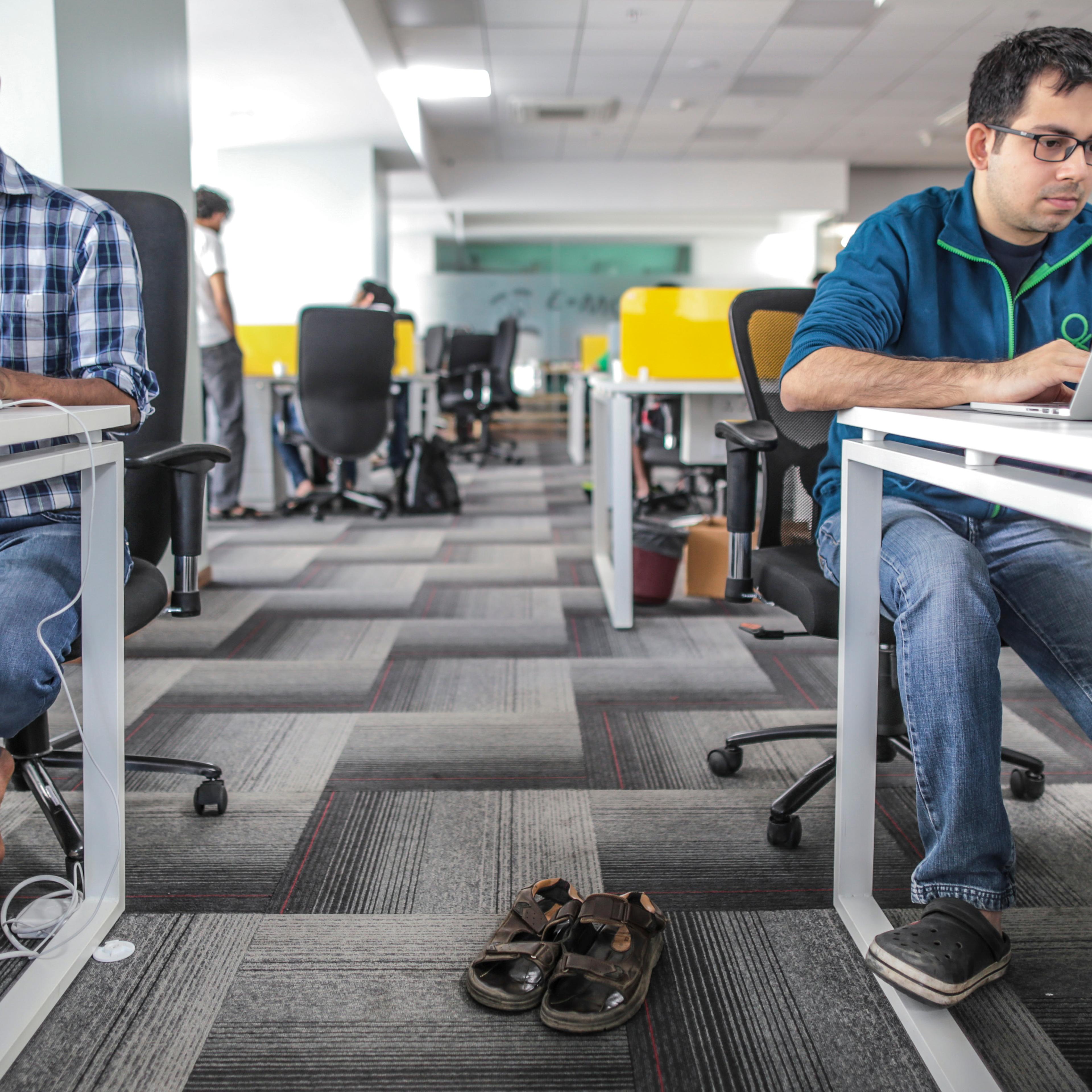Tiny Owl employees work on laptop computers as pair of sandals sit on the floor inside the company's head office in Mumbai, India, on Monday, March. 9, 2015.
