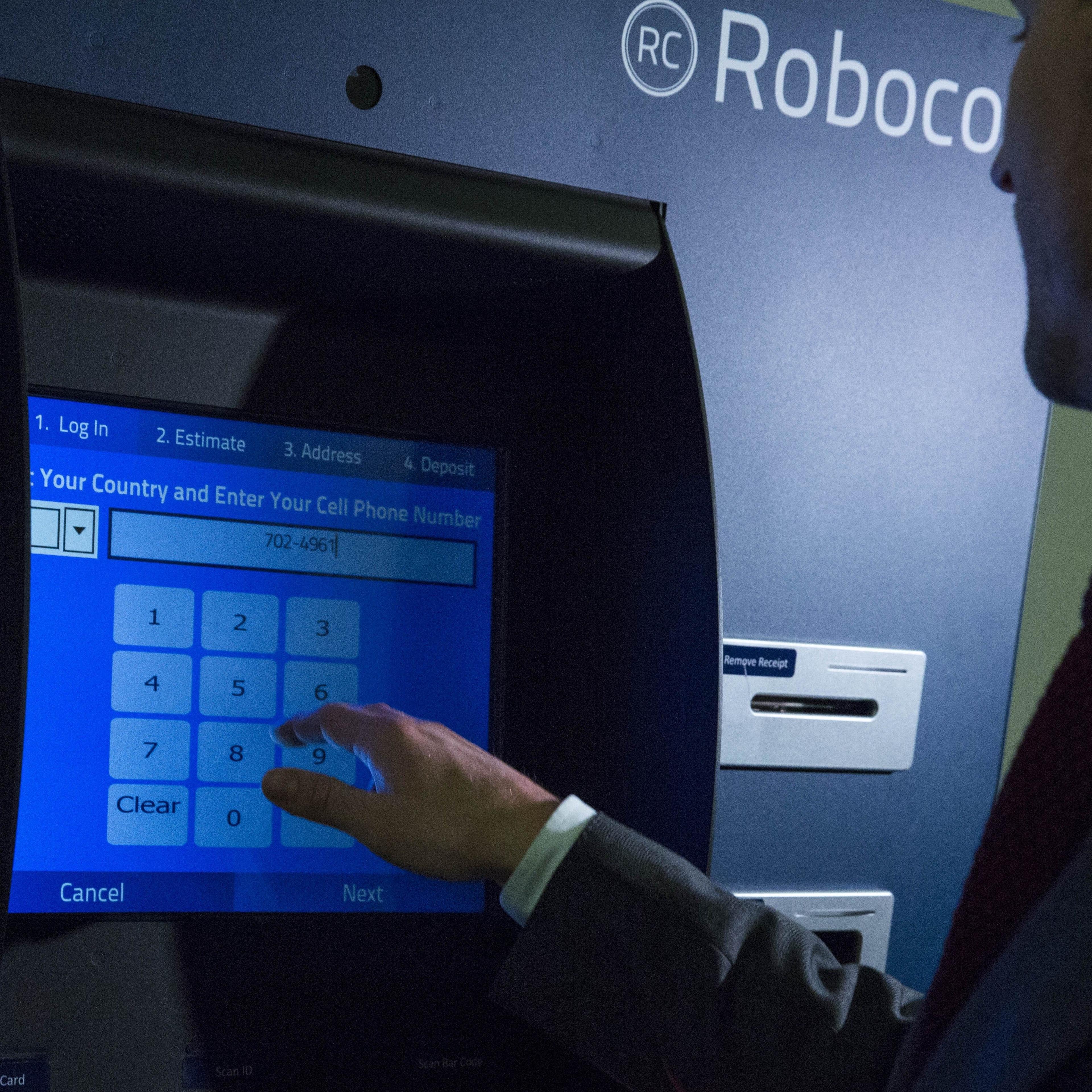 Representatives Of A Bitcoin Kiosk Company Demonstrate The Currency Product On Capitol Hill