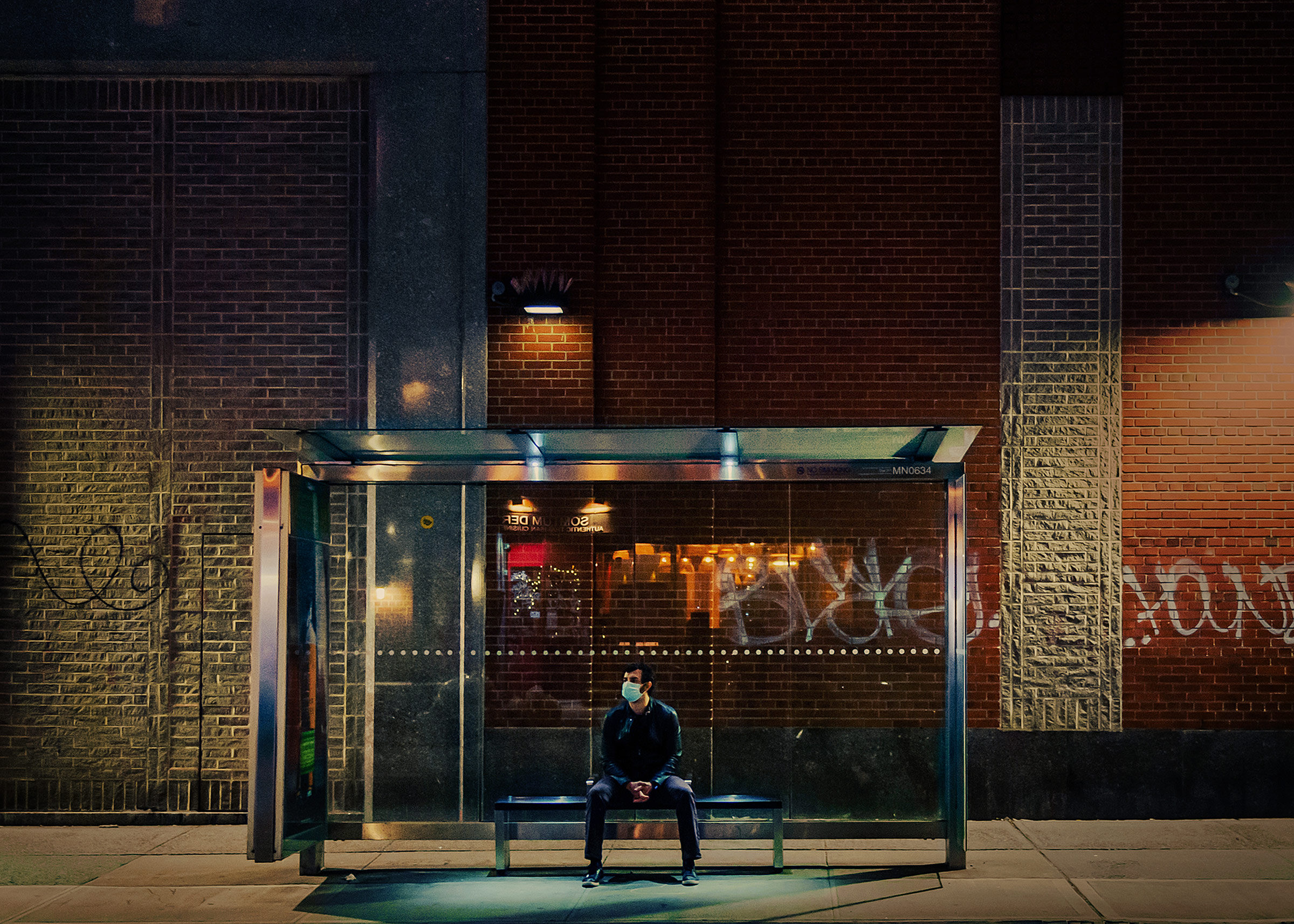 A man sits at a bus stop in New York City on May 7, 2020, at the height of the first wave