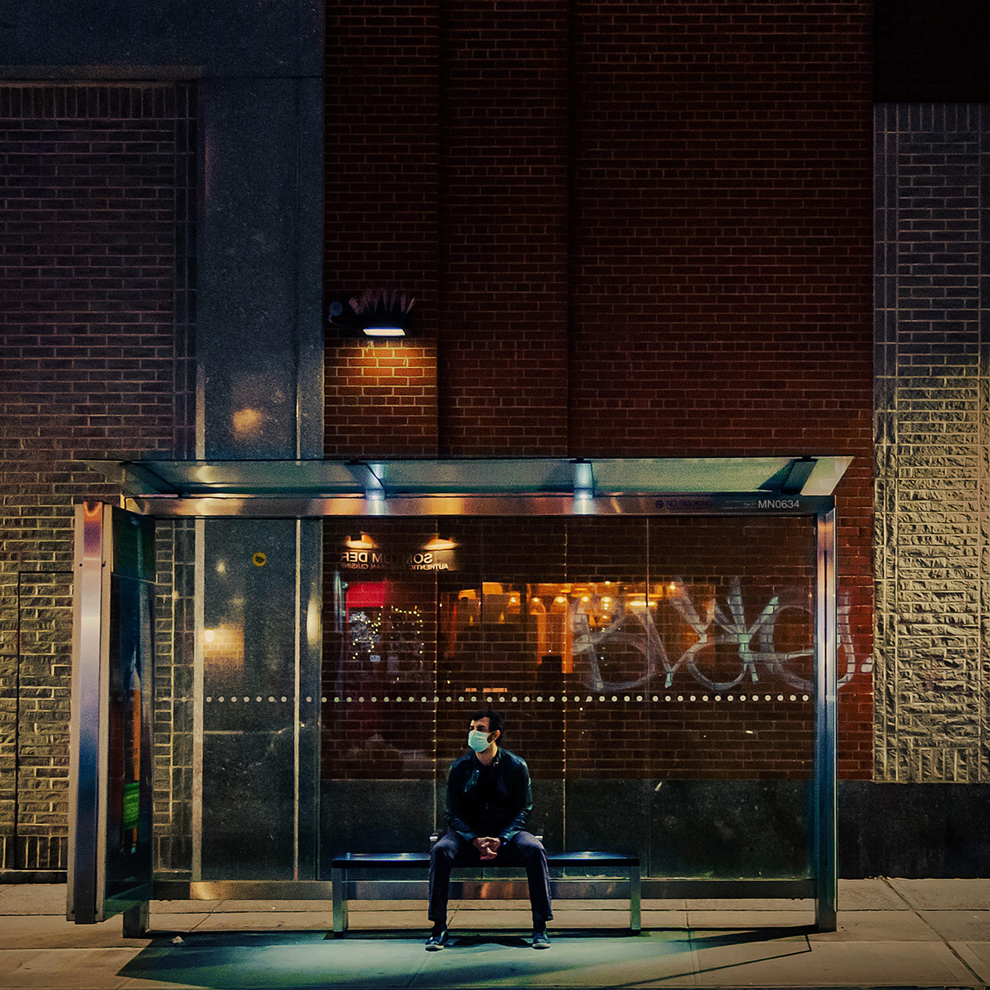 A man sits at a bus stop in New York City on May 7, 2020, at the height of the first wave