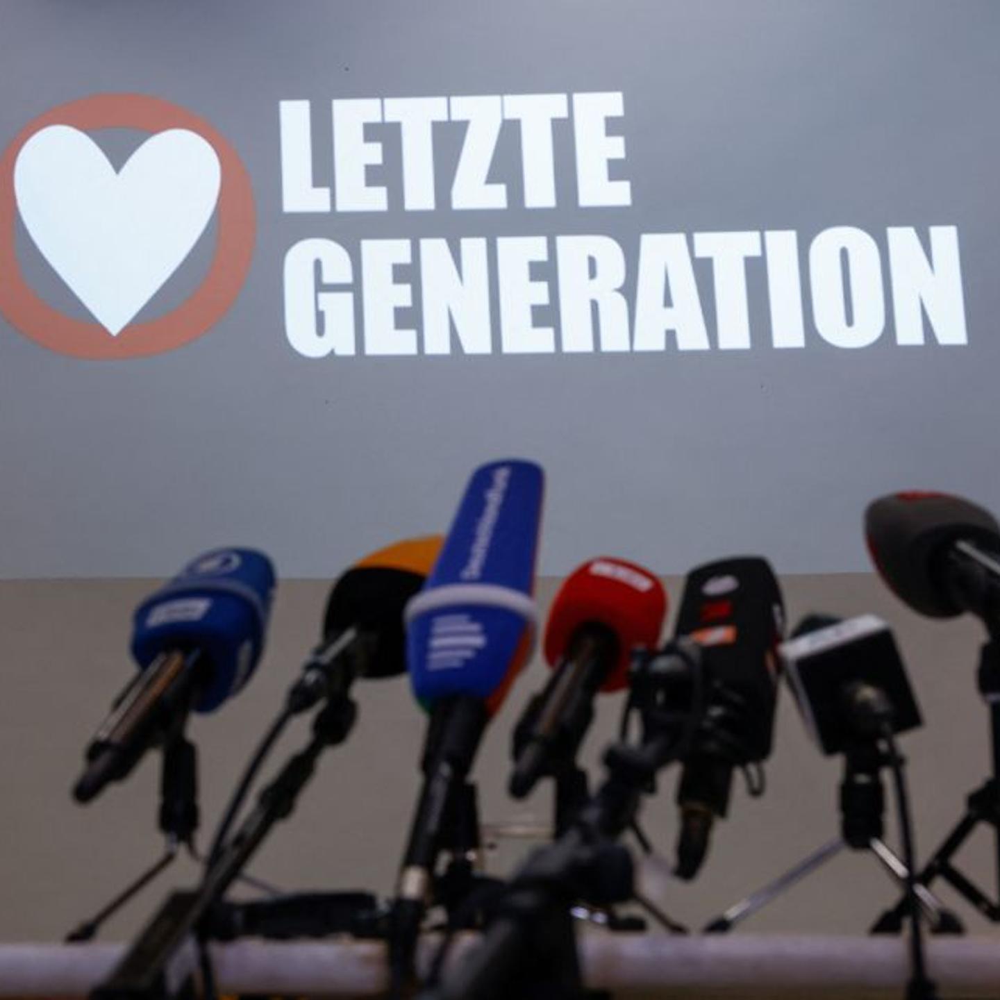 The logo of the "Letzte Generation" (Last Generation) group is seen behind a row of microphones ahead of a news conference in Berlin on May 24, 2023 following early morning raids by police on their activists.