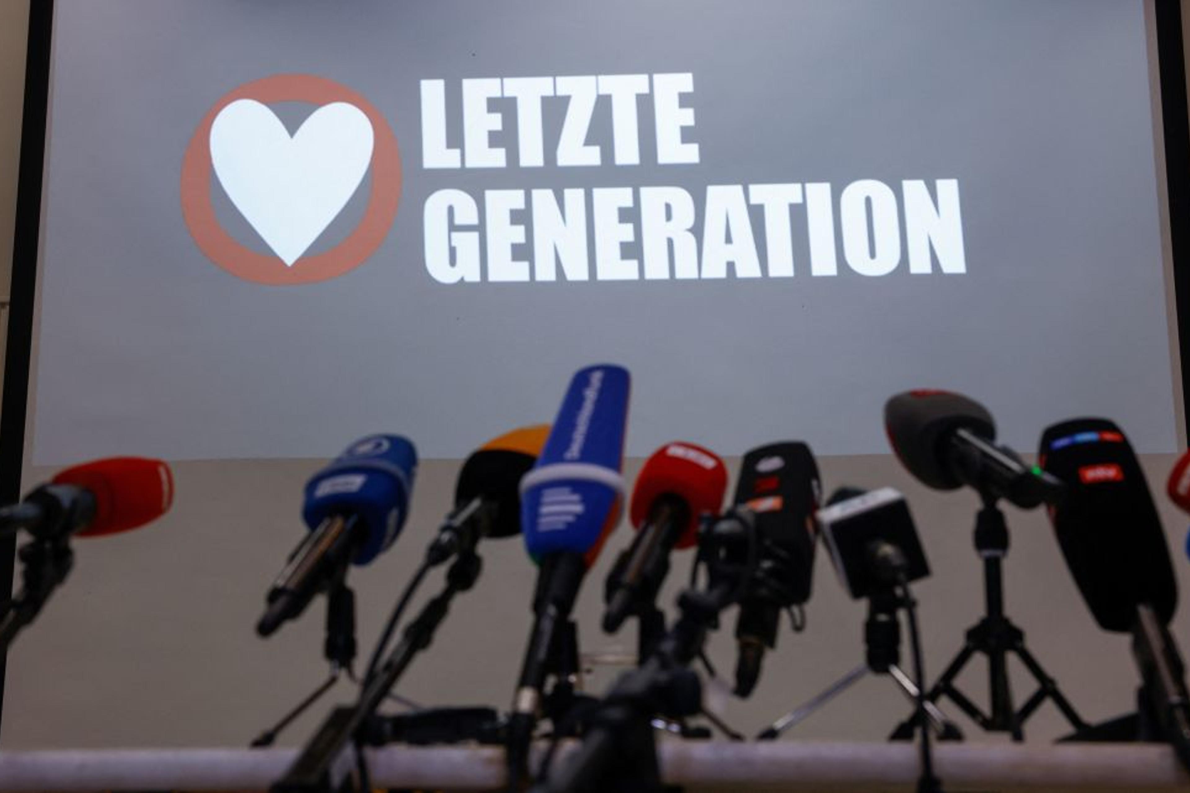 The logo of the "Letzte Generation" (Last Generation) group is seen behind a row of microphones ahead of a news conference in Berlin on May 24, 2023 following early morning raids by police on their activists.