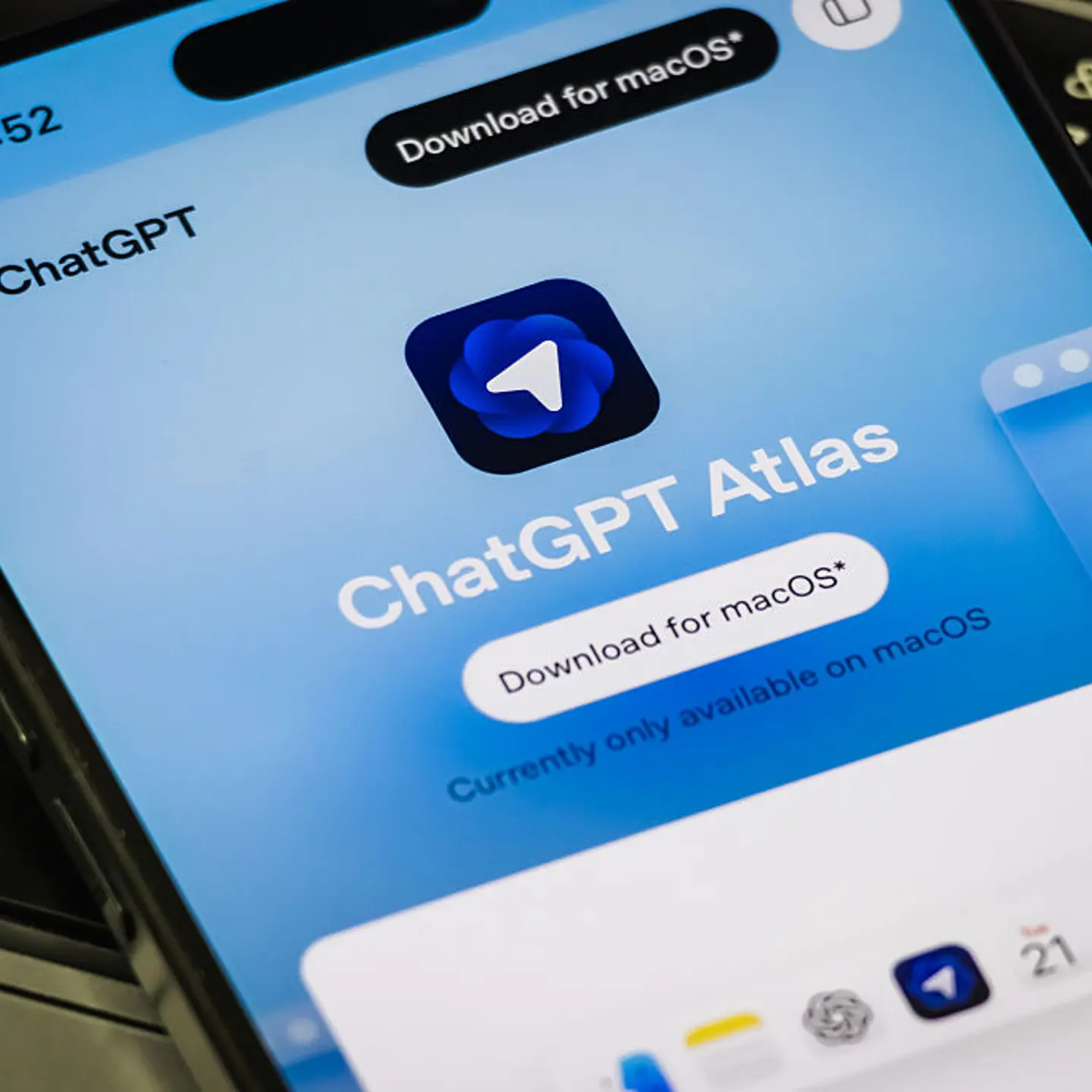 ChatGPT Atlas website displayed on smartphone placed on laptop keyboard
