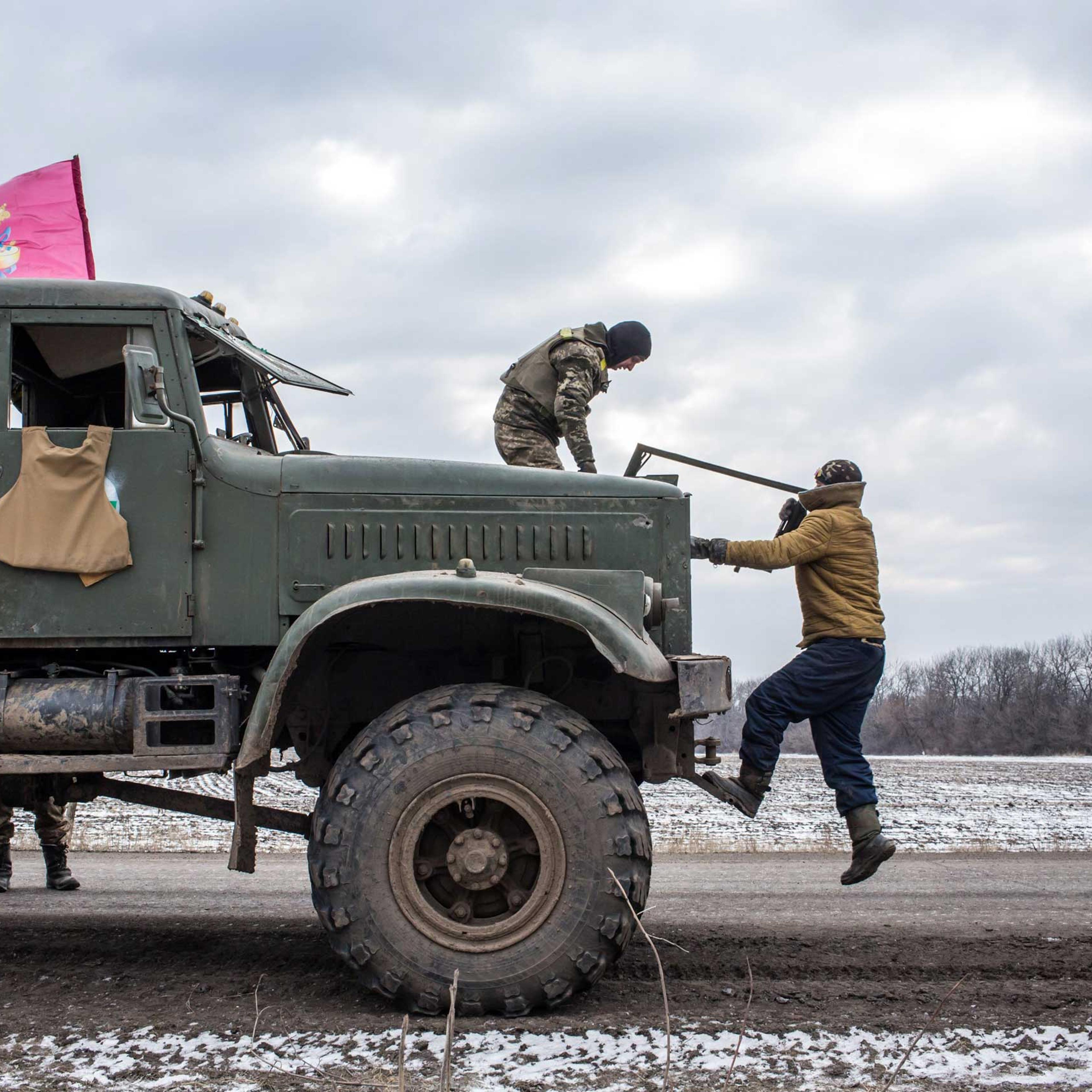 Ukrainian soldiers from a unit based in Zaporizhia repair the bullet-shattered windshield of a truck after taking fire during their withdrawal from Debaltseve the previous day on Feb. 19, 2015 in Artemivsk.
