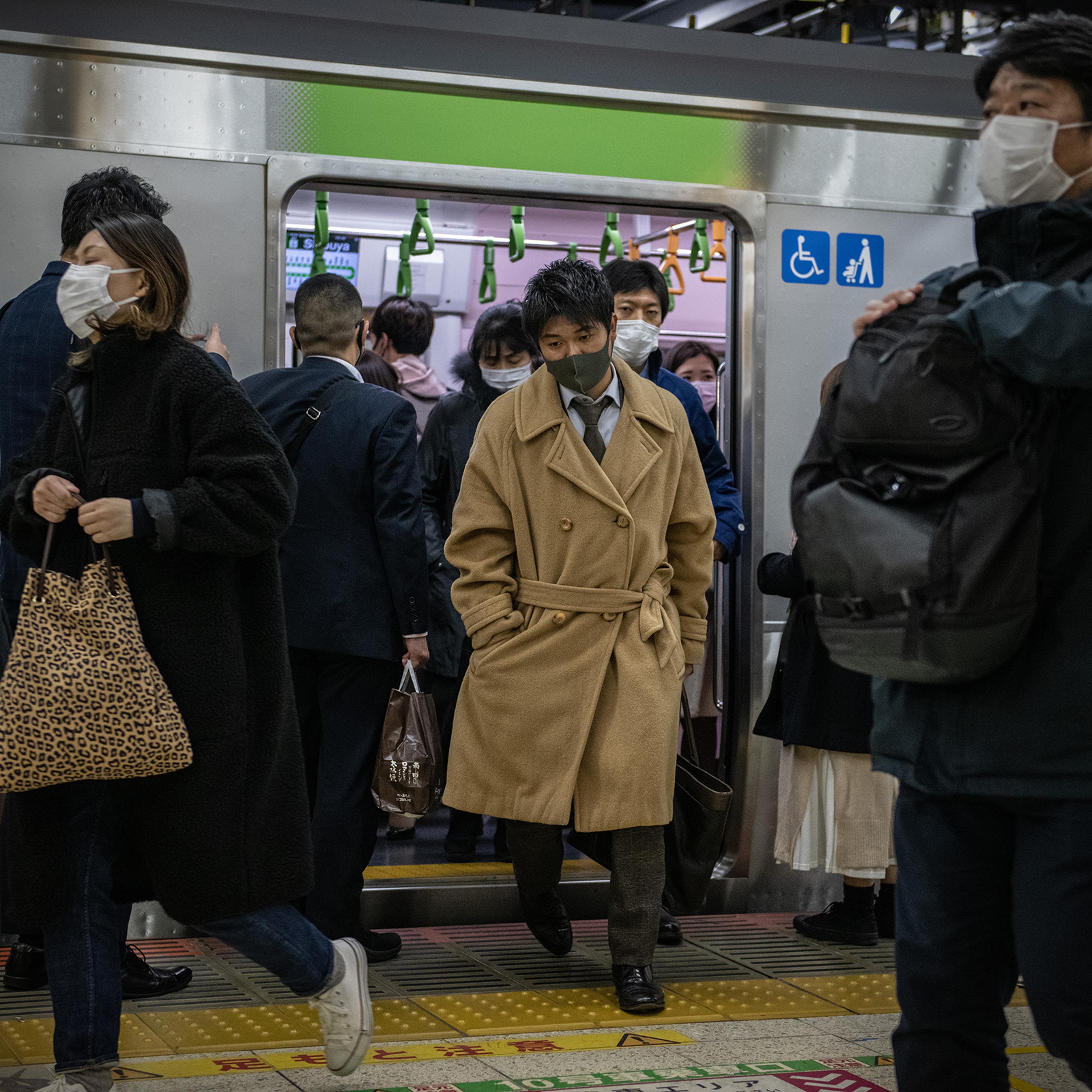 People wearing face masks disembark a Yamanote Line train on Dec. 16 in Tokyo