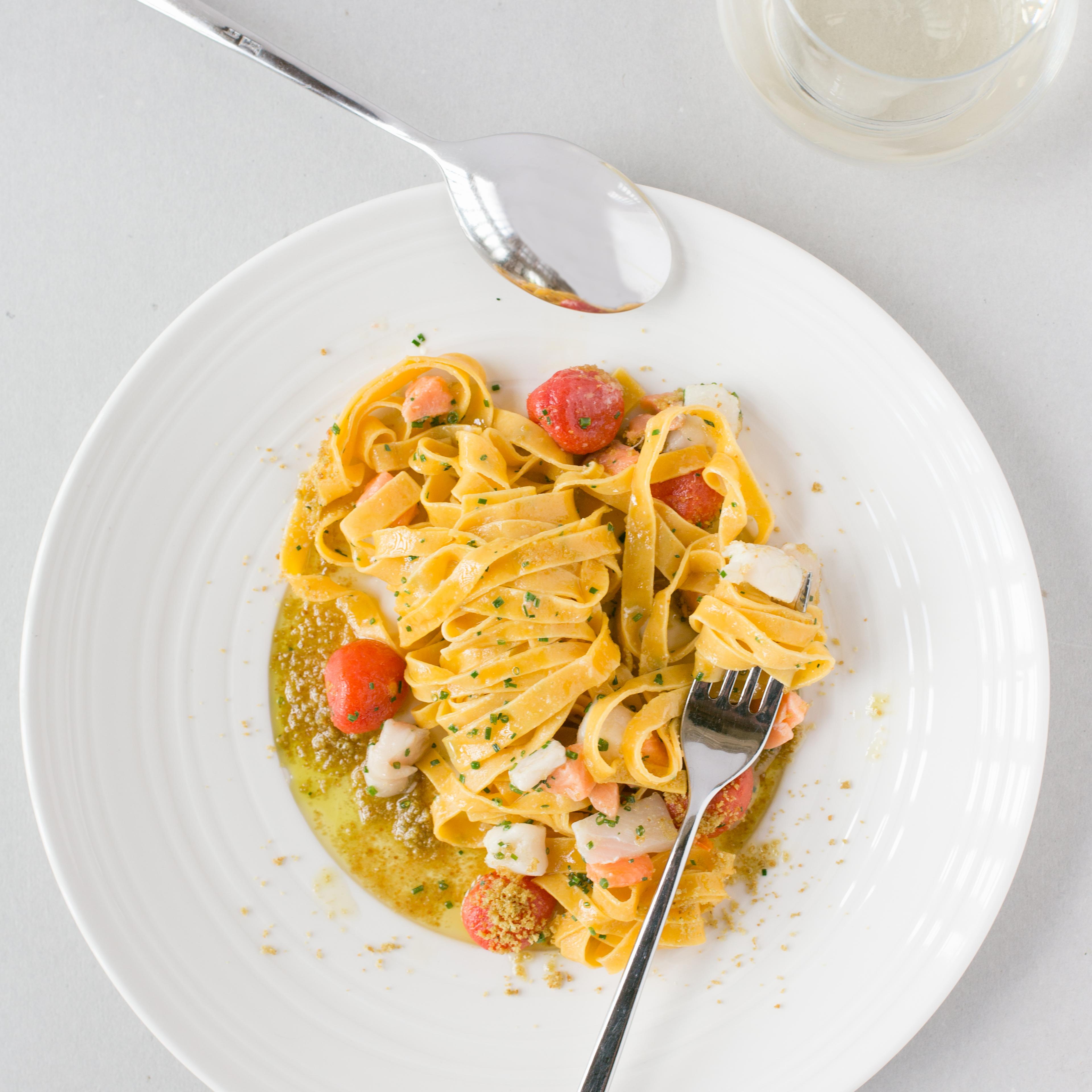 Plate of sea food pappardelle with cherry tomatoes