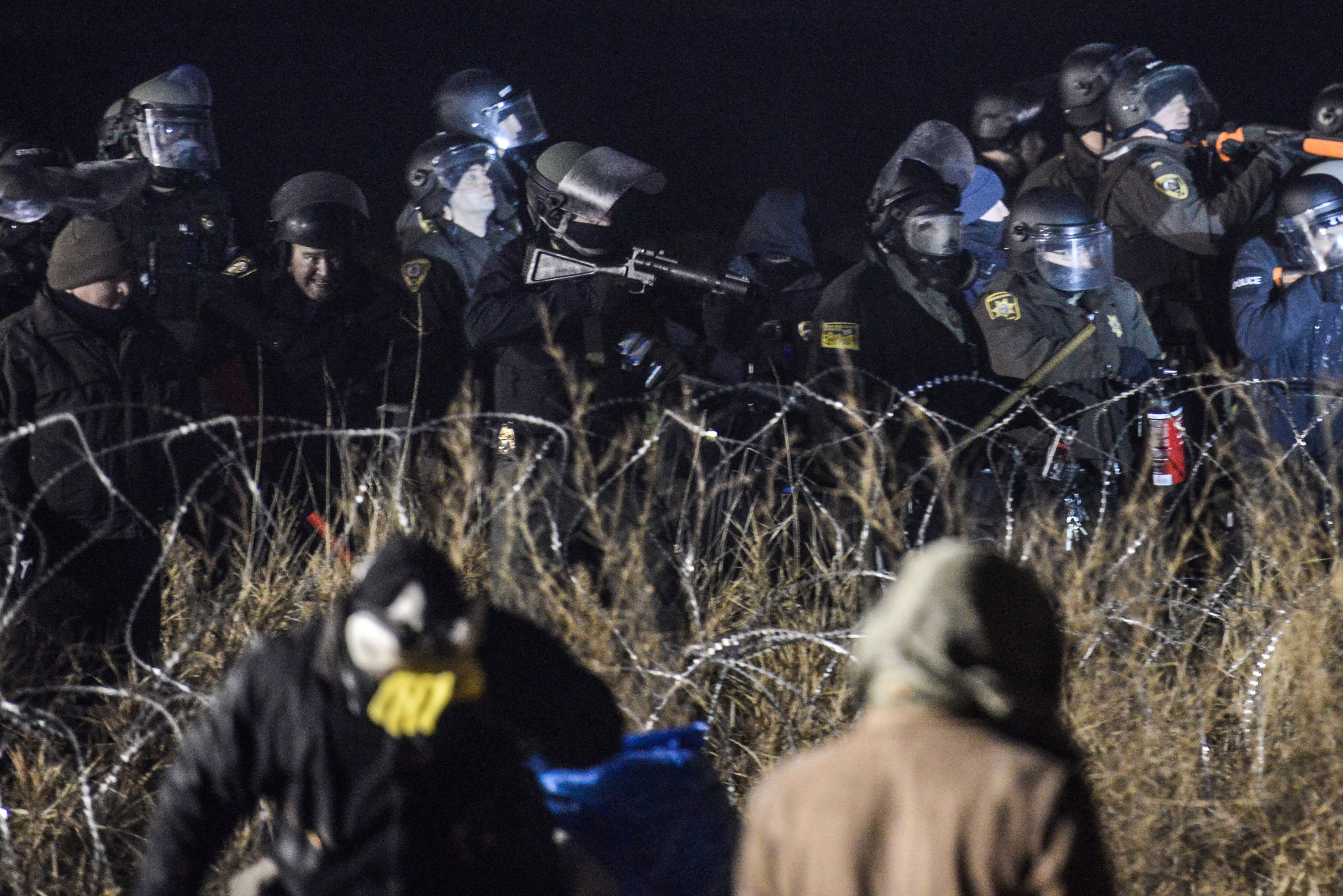Police confront protesters with a rubber bullet gun during a protest against plans to pass the Dakota Access pipeline near the Standing Rock Indian Reservation, near Cannon Ball, North Dakota, U.S. November 20, 2016. REUTERS/Stephanie Keith TPX IMAGES OF