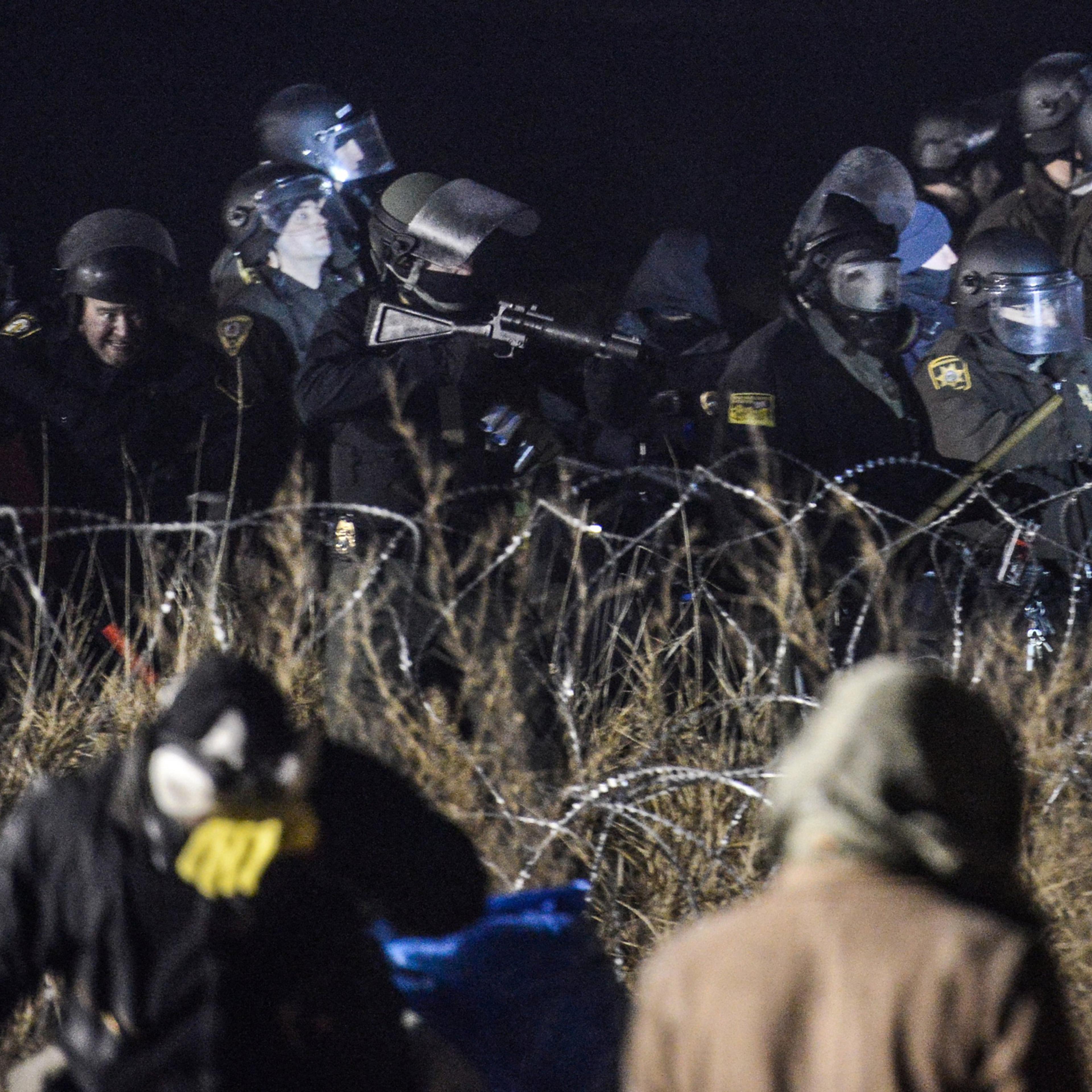 Police confront protesters with a rubber bullet gun during a protest against plans to pass the Dakota Access pipeline near the Standing Rock Indian Reservation, near Cannon Ball, North Dakota, U.S. November 20, 2016. REUTERS/Stephanie Keith TPX IMAGES OF