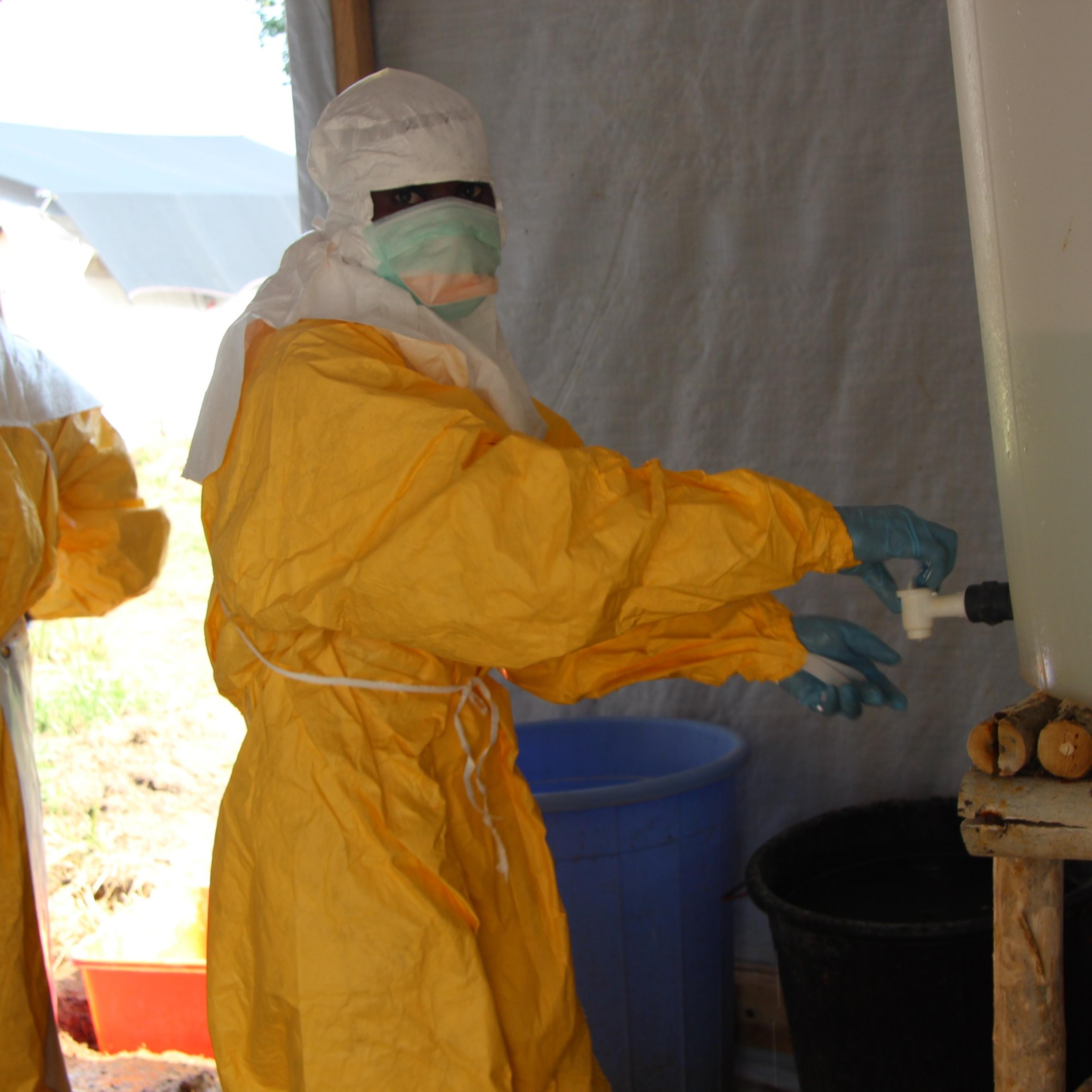 Hygienists wearing protective suits disinfect the toilets of the Ebola treatment centre in Lokolia, on October 5, 2014.