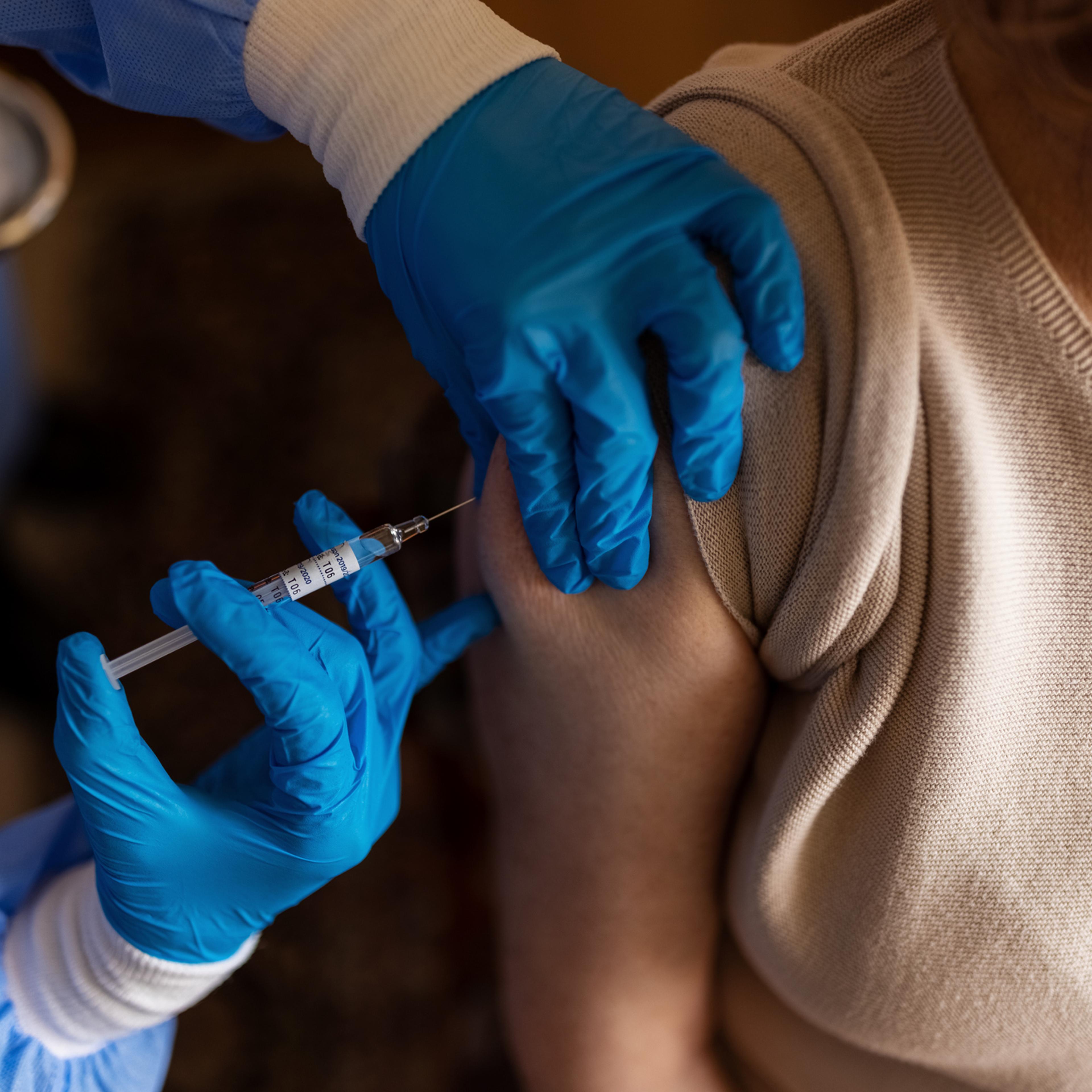 Senior female getting vaccinated at home