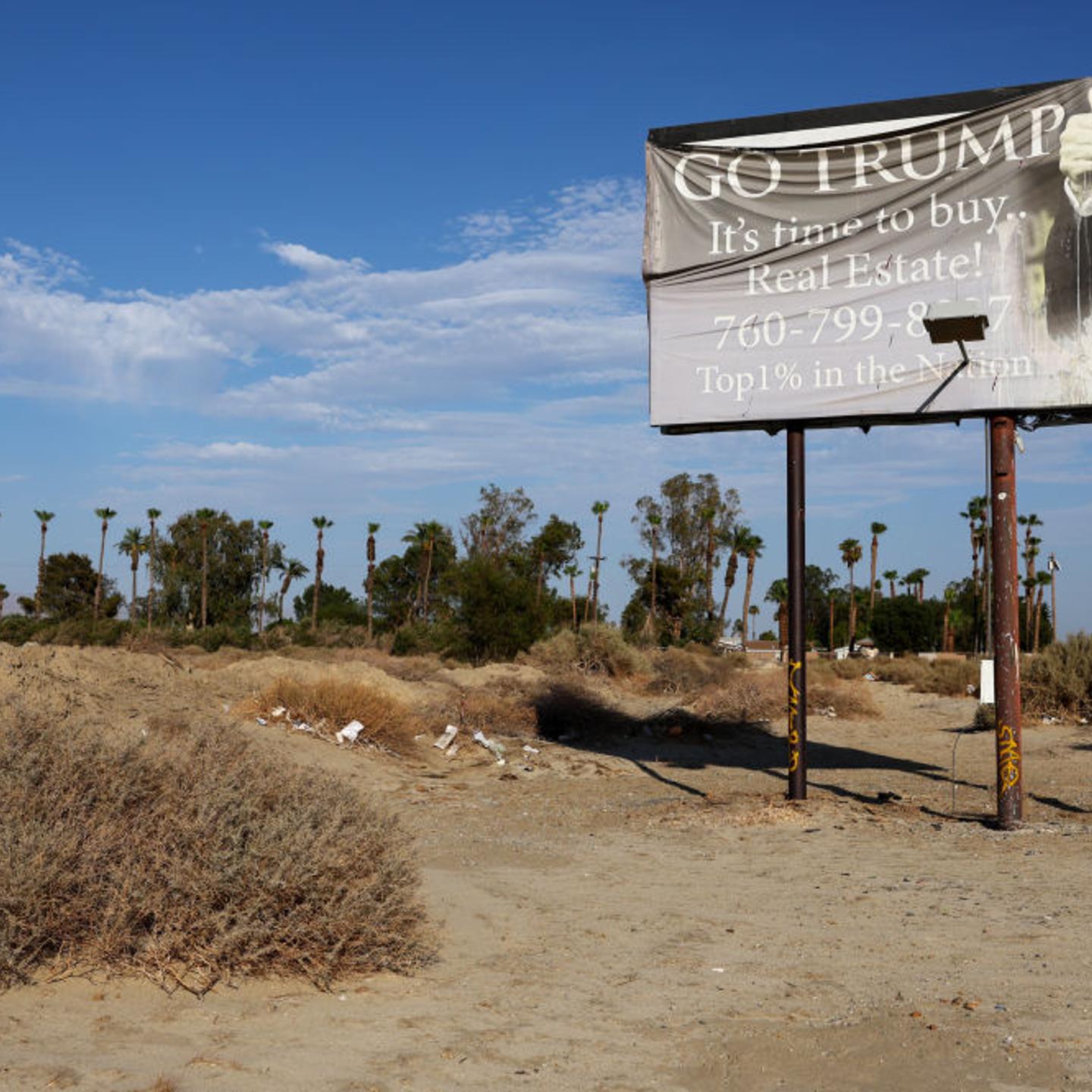 A faded billboard reads 'Go Trump It's time to buy Real Estate!' on July 13, 2022