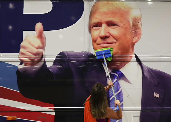 Bailey McDaniel wipes off the side of the campaign bus of Republican presidential candidate Donald Trump before his campaign rally at the South Florida Fair Expo Center on October 13, 2016 in West Palm Beach, Florida.