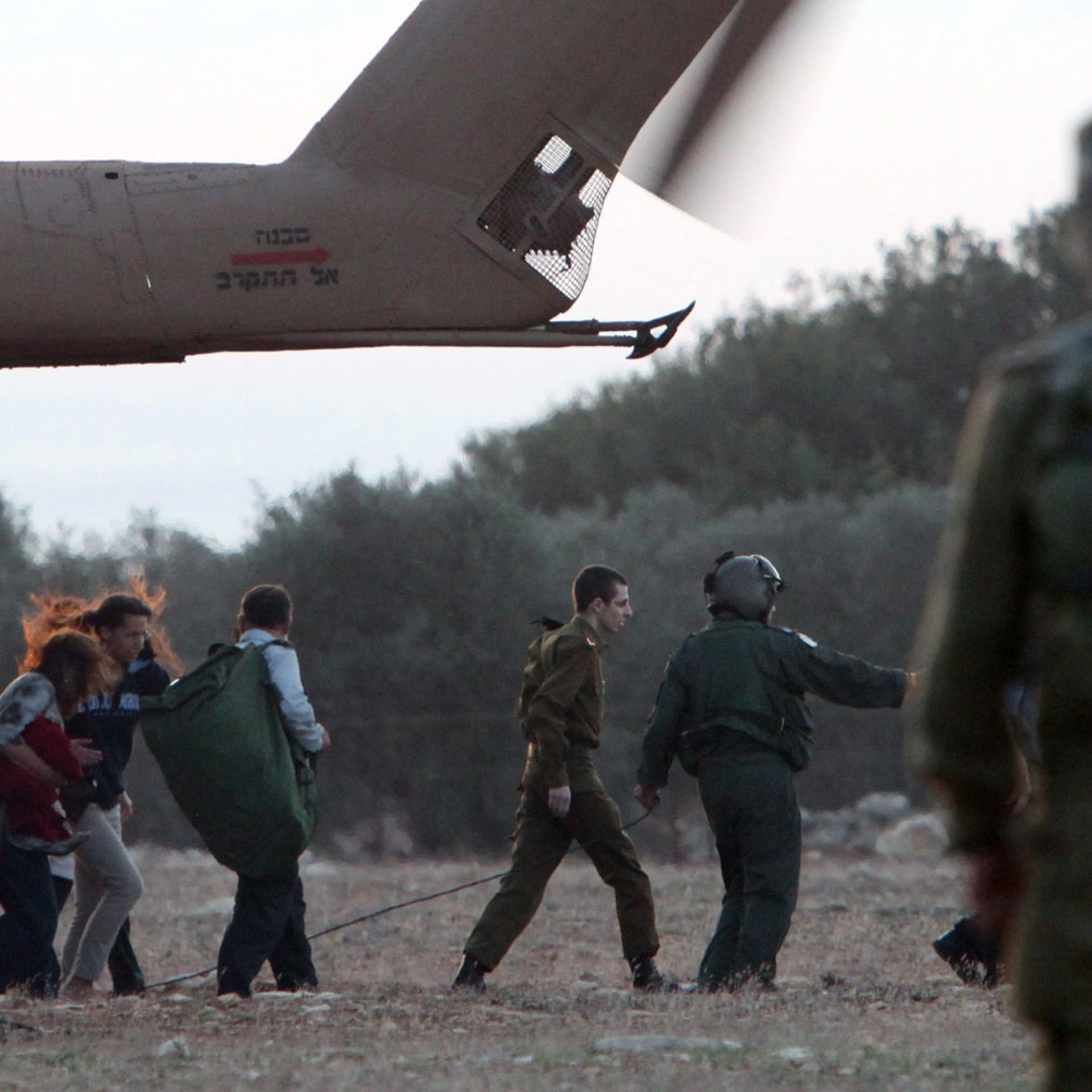 October 18, 2011. In the company of members of his family, Israeli soldier Gilad Shalit is guided from an army helicopter. After being captured by Hamas militants in 2006 and spending five years in captivity in Gaza, Shalit was freed in exchange for the release of more than 1,000 Palestinians from Israeli jails.