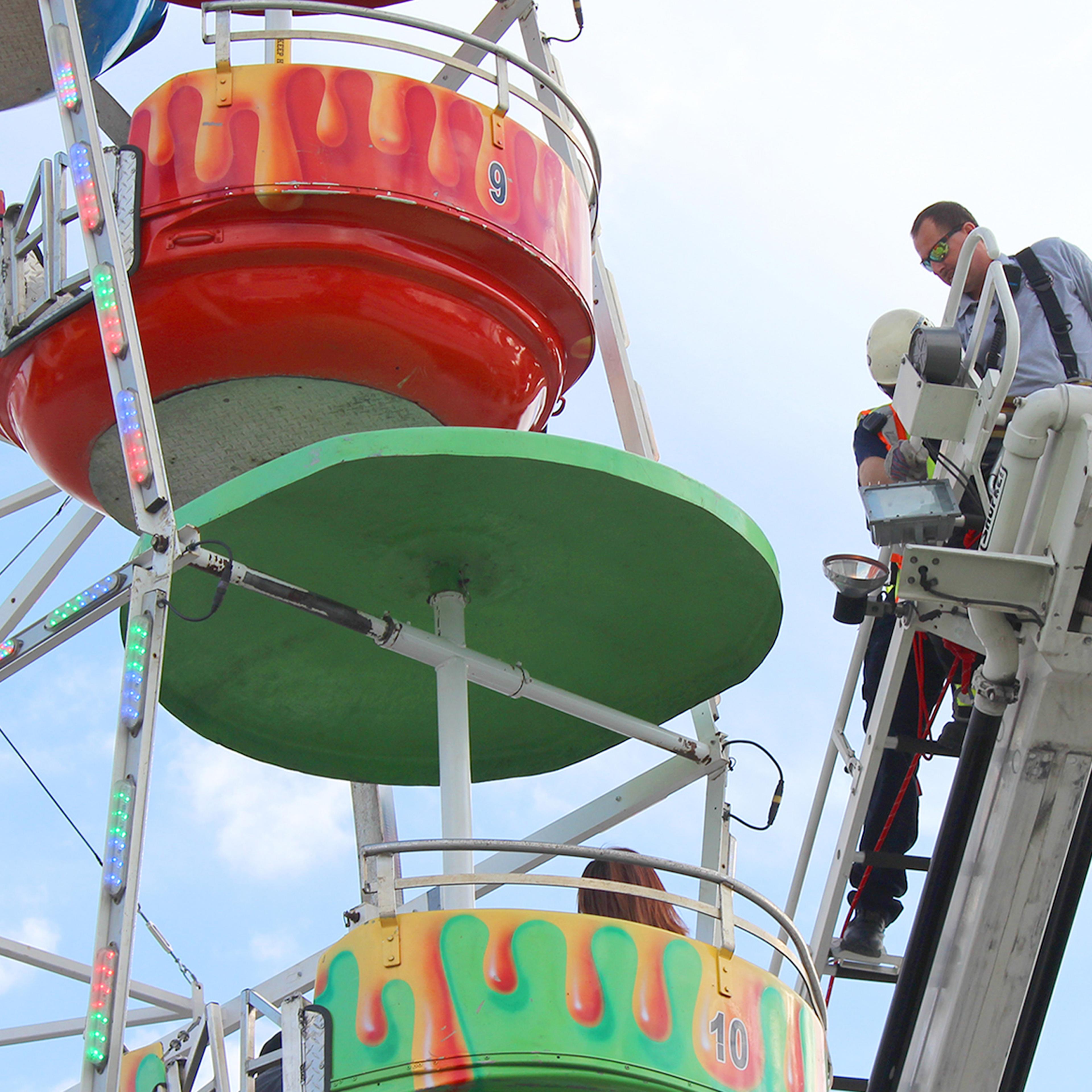 Members of the Greeneville Fire Department help people off the ferris wheel at the Greene County Fair in Greeneville, Tenn. on Aug. 8, 2016.