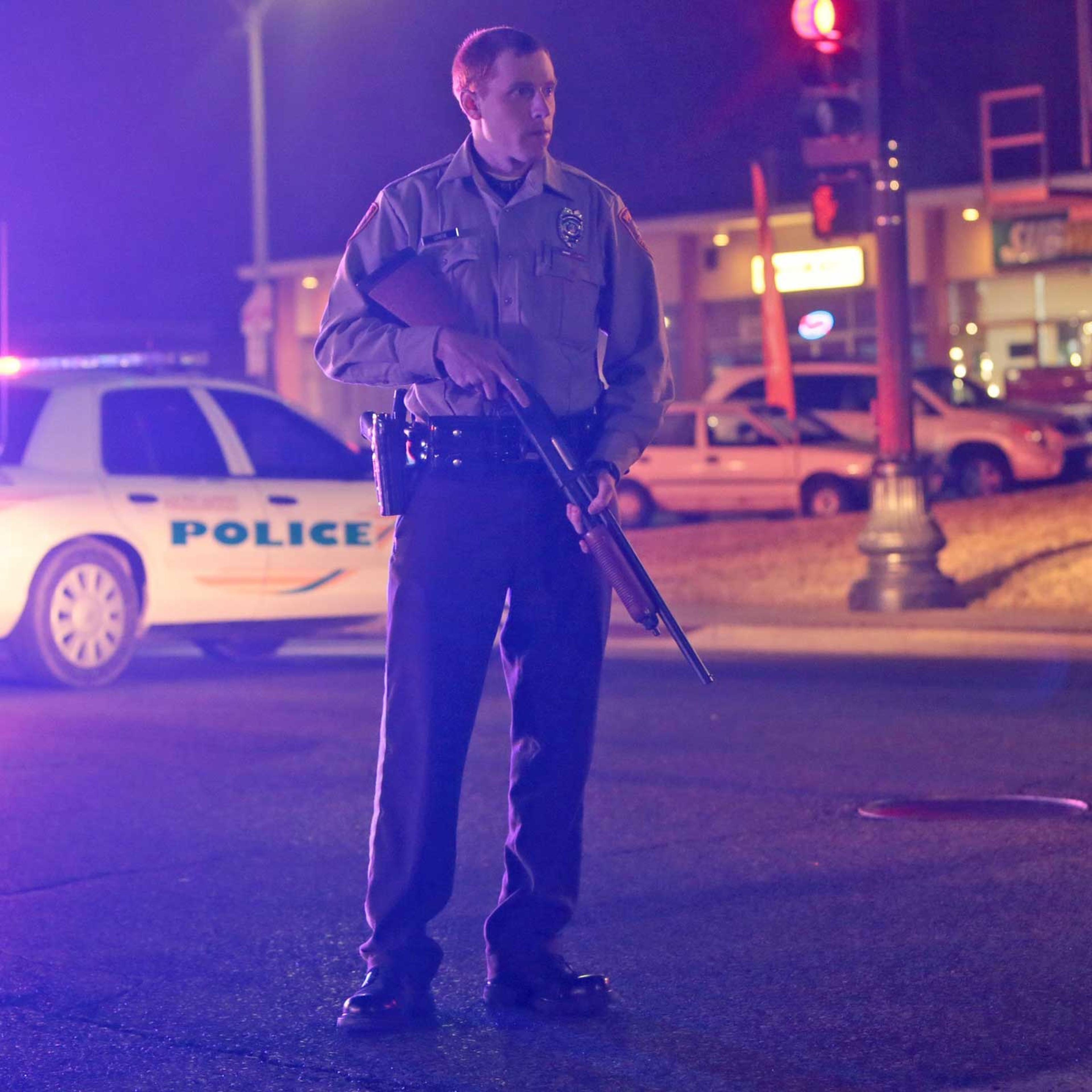 Police guard the corner off Adams Street and South Florissant Rd after two officers were shot while standing guard in front of the Ferguson Police Station on March 12, 2015.