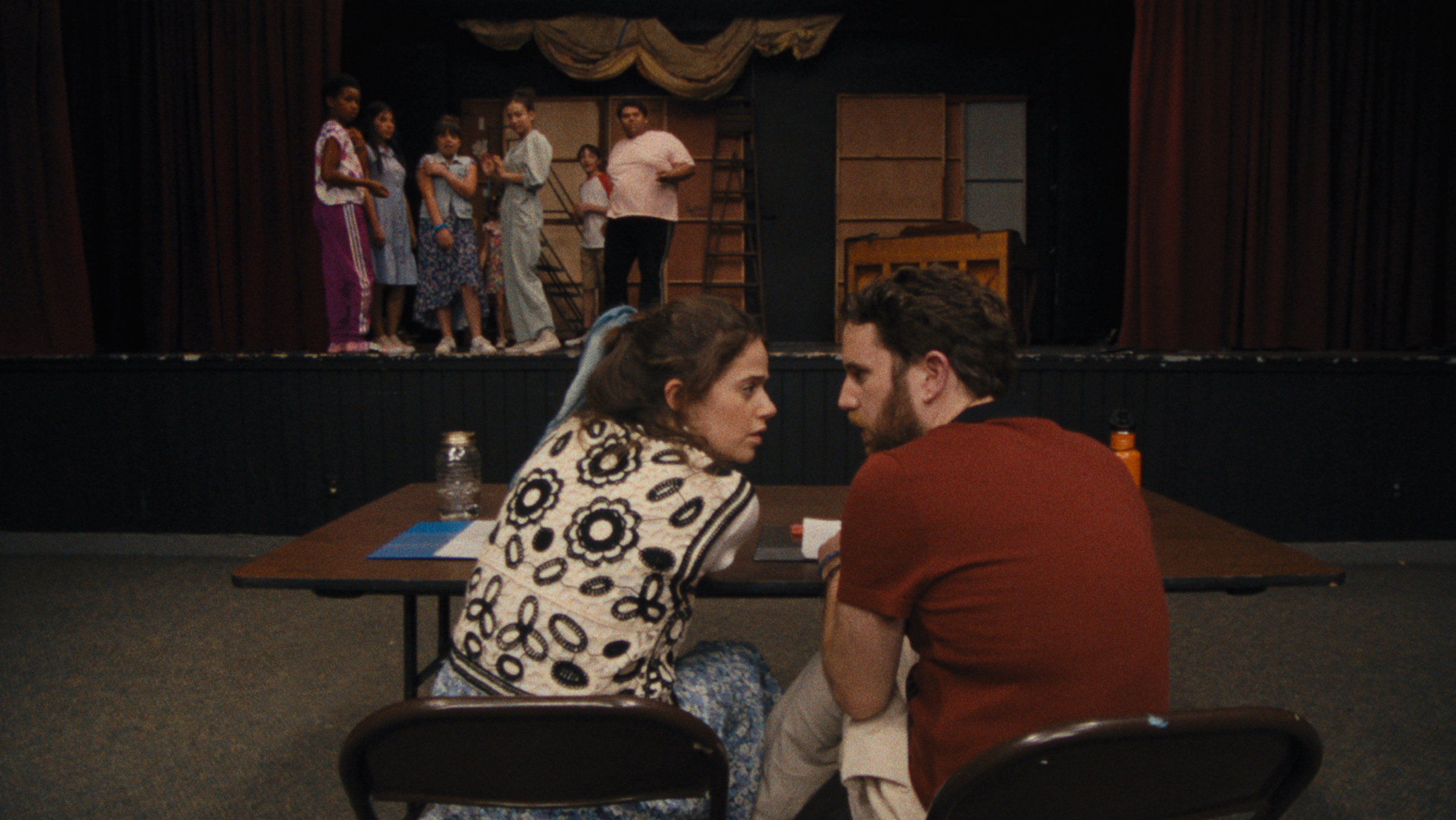 Theater instructors Rebecca-Diane (Molly Gordon) and Amos (Ben Platt) confer as a group of campers looks on.