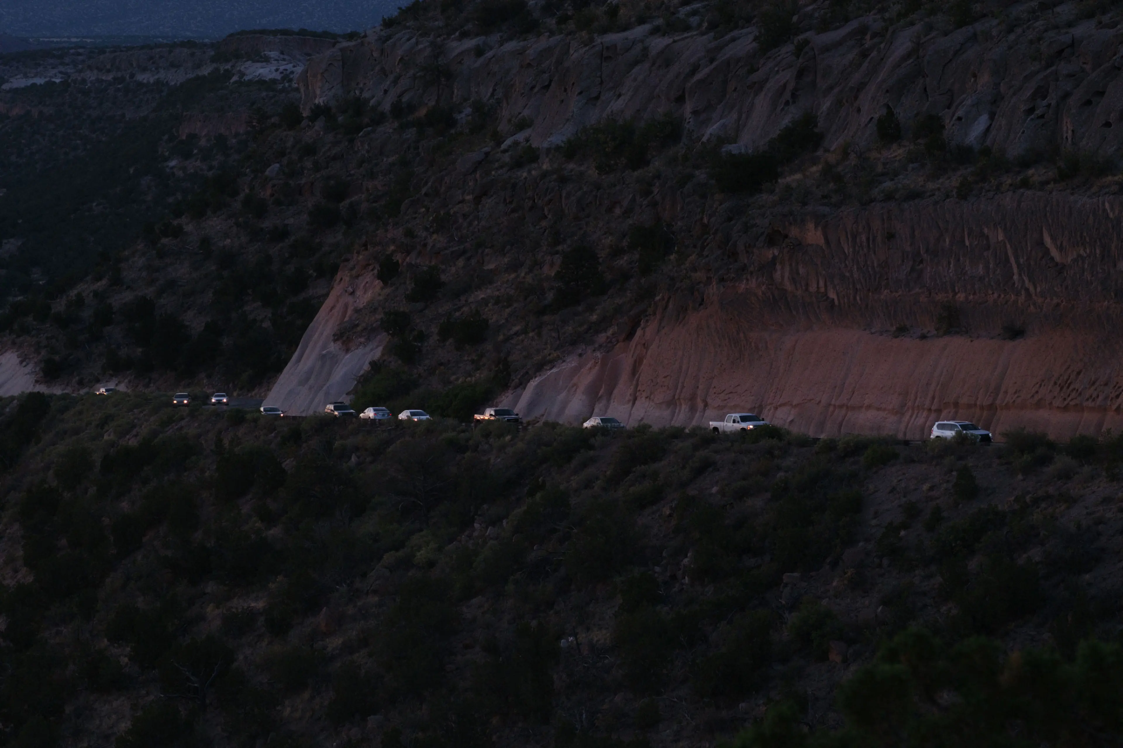 cars lined up on a road leading into Los Alamos