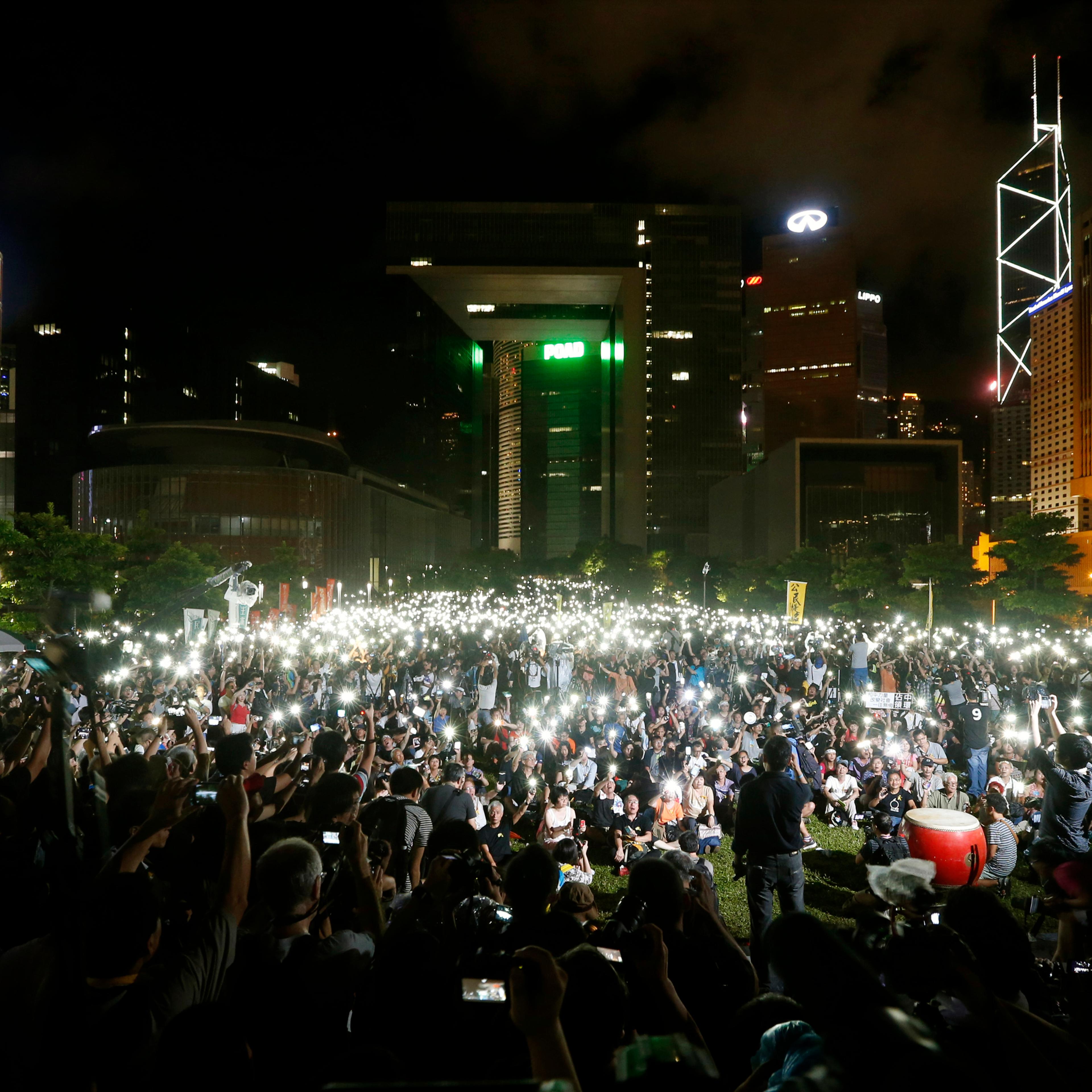 Pro-democracy protesters switch on their mobile phones during a campaign to kick off the Occupy Central civil disobedience event in Hong Kong