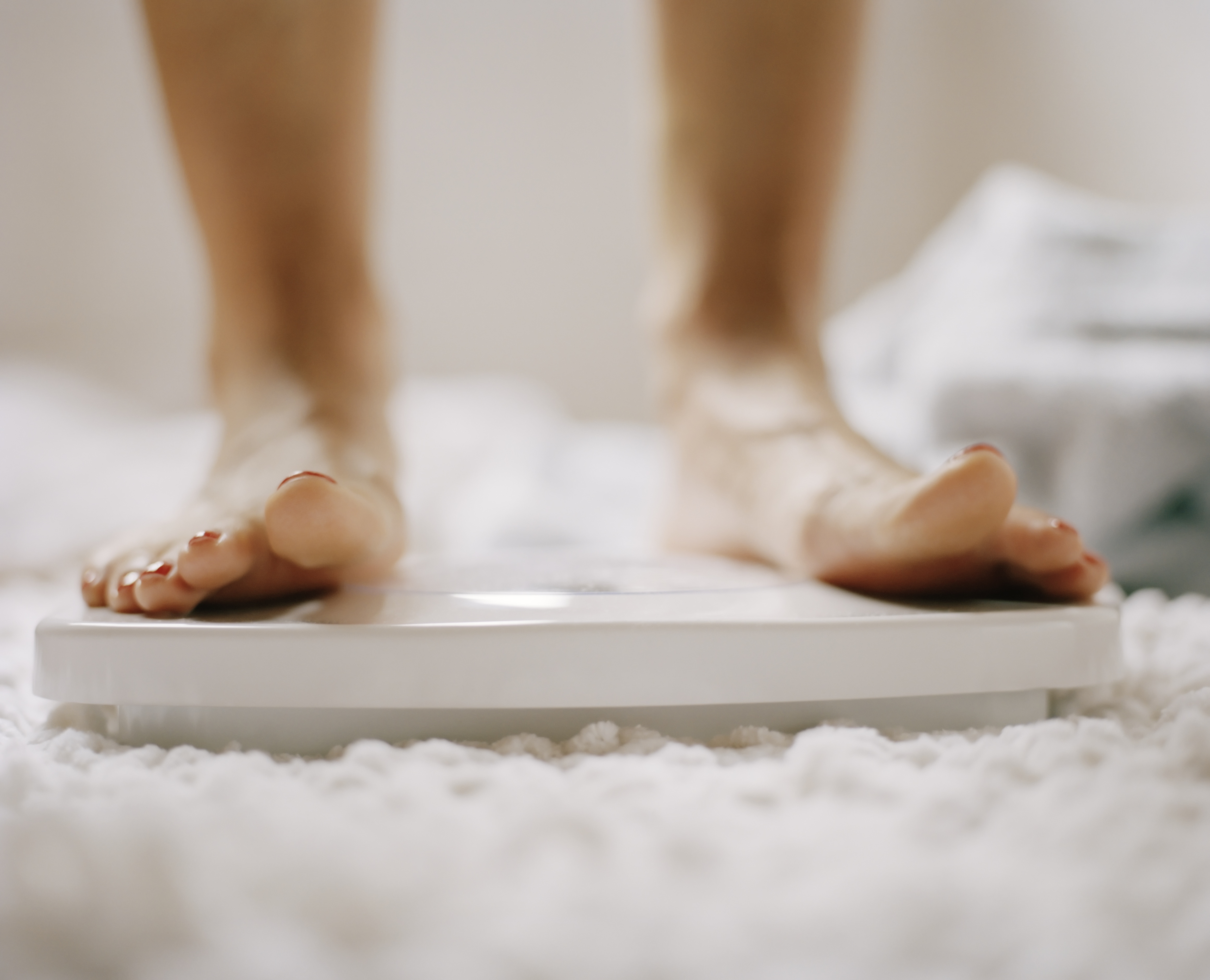 Close-up of woman's feet on scale TIME health stock