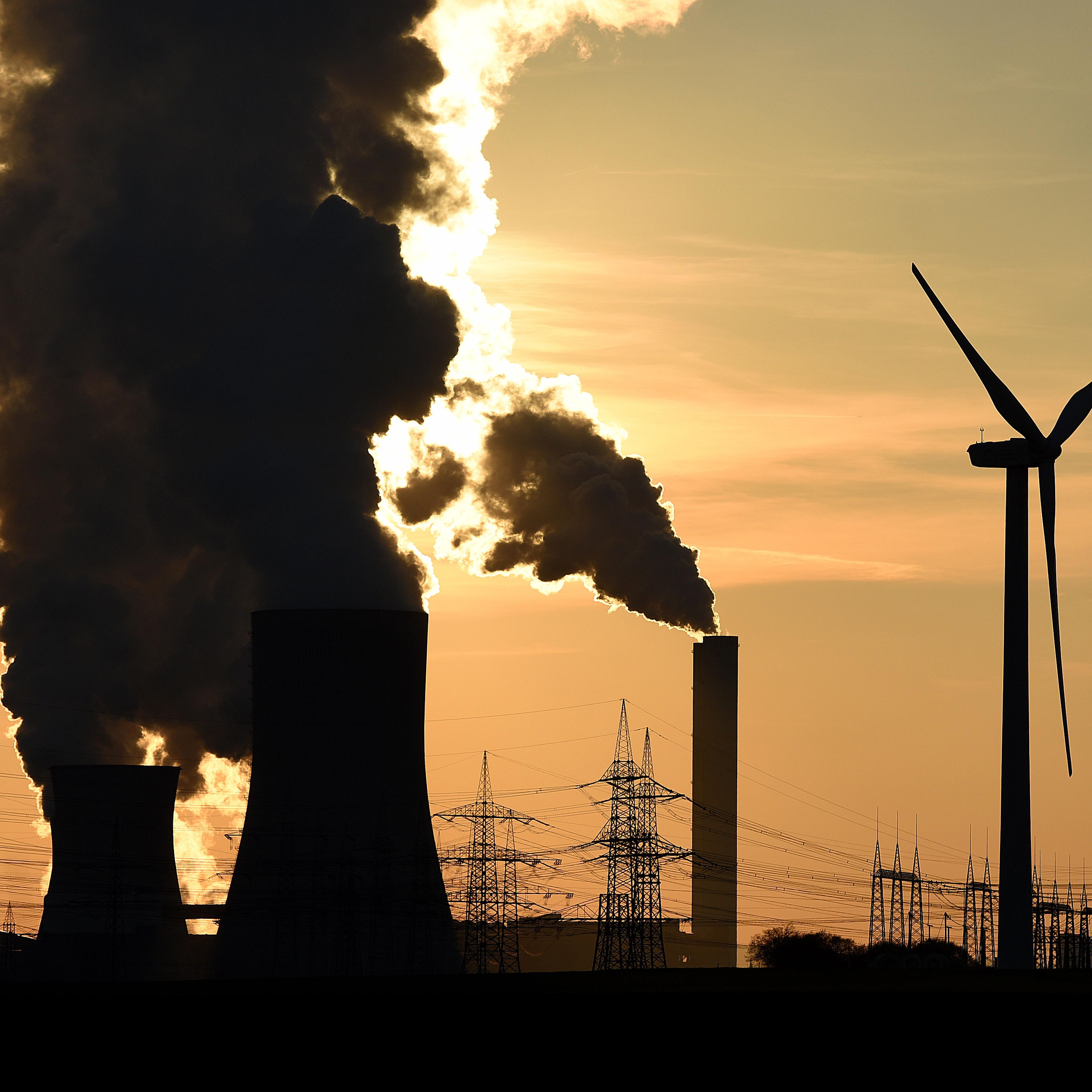 Electricity pylons and wind turbines stand beside the RWE Niederaussem coal-fired power plant while Steam rises from cooling towers on February 16, 2016 near Bergheim, Germany.