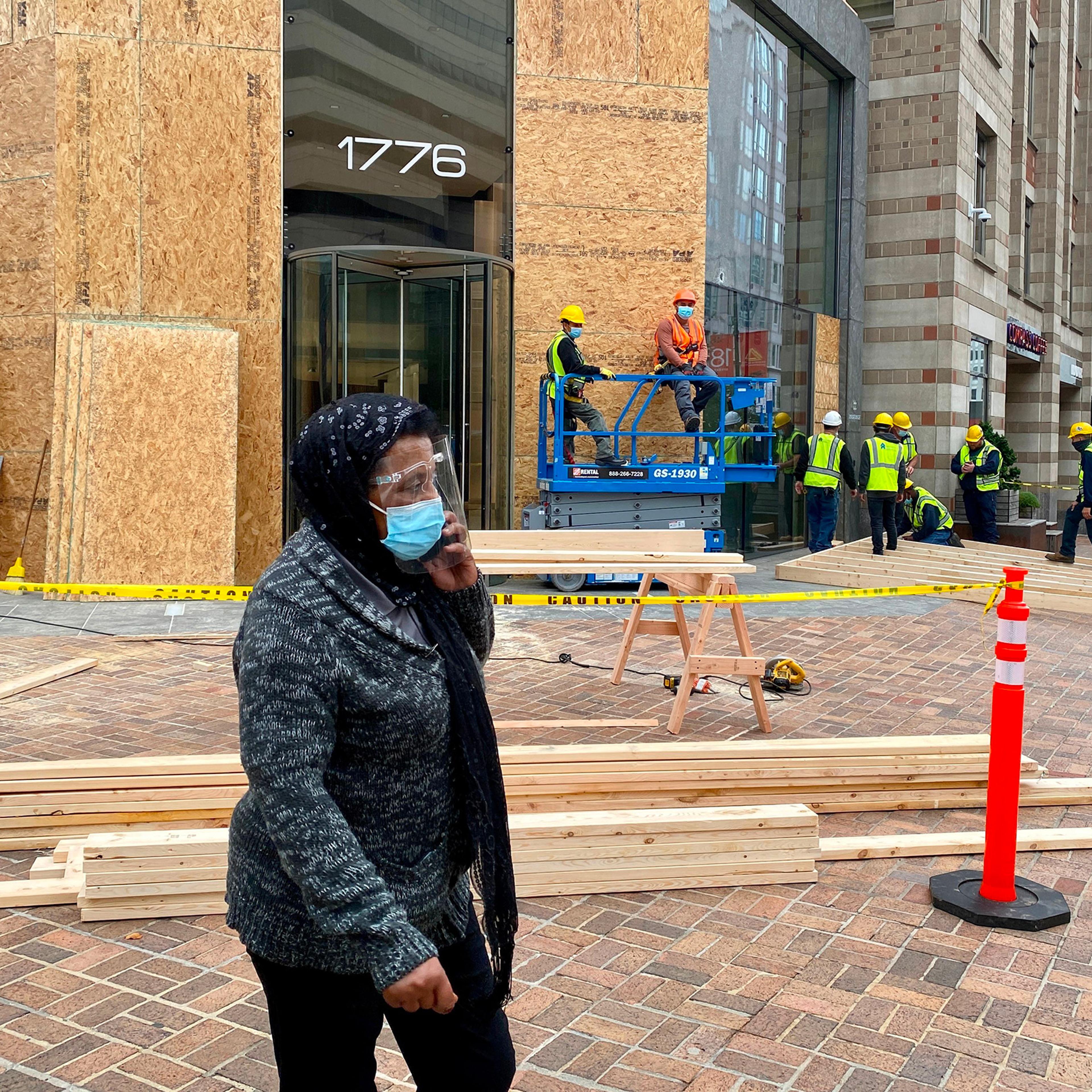 Workers install protections on building facades near the White House as building managers and local businesses fear violent demonstrations ahead of the coming Presidential elections, on Oct. 26