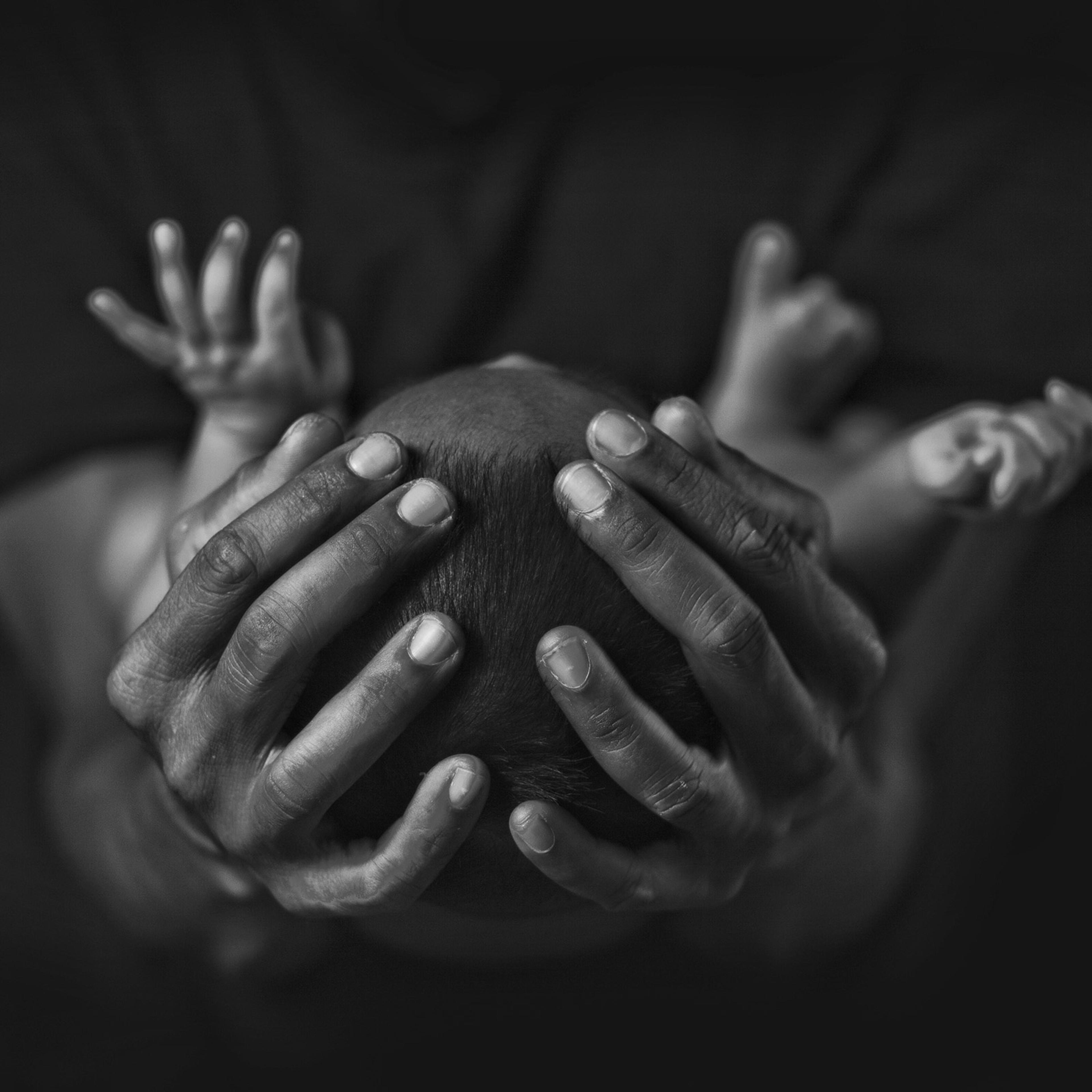 Midsection Of Mother Carrying Baby Against Black Background