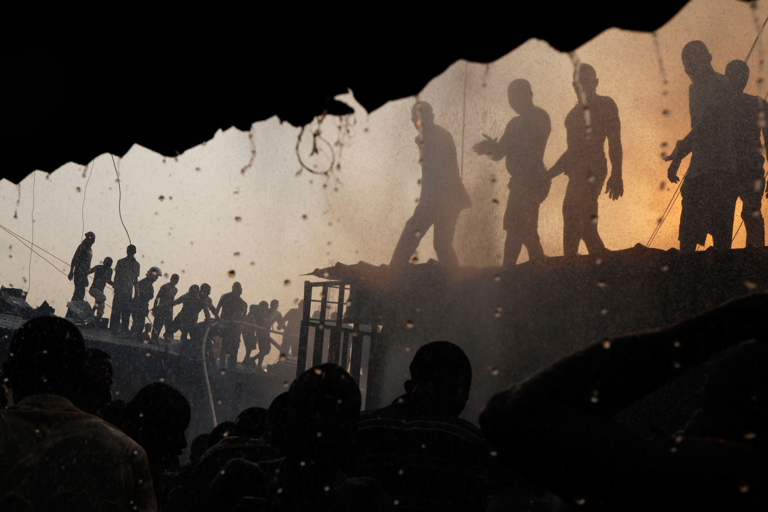 January 23, 2012. Residents struggle to drown a fire in a slum in central Malano in
Equatorial Guinea. The country is co-hosting the African Cup of Nations tournament and has been criticized for pouring money into the games while 7 in 10 of its citizens live in poverty and 1 in 5 children dies before the age of 5.