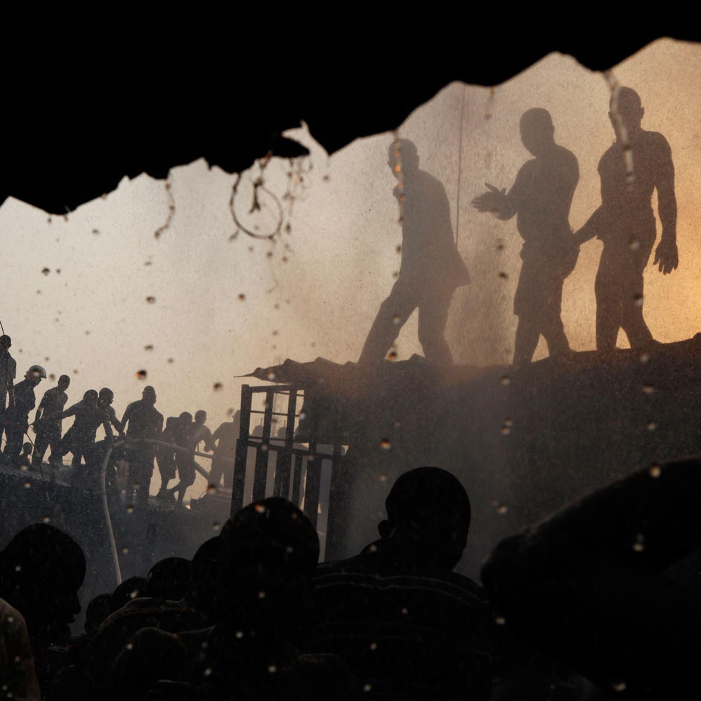 January 23, 2012. Residents struggle to drown a fire in a slum in central Malano in
Equatorial Guinea. The country is co-hosting the African Cup of Nations tournament and has been criticized for pouring money into the games while 7 in 10 of its citizens live in poverty and 1 in 5 children dies before the age of 5.