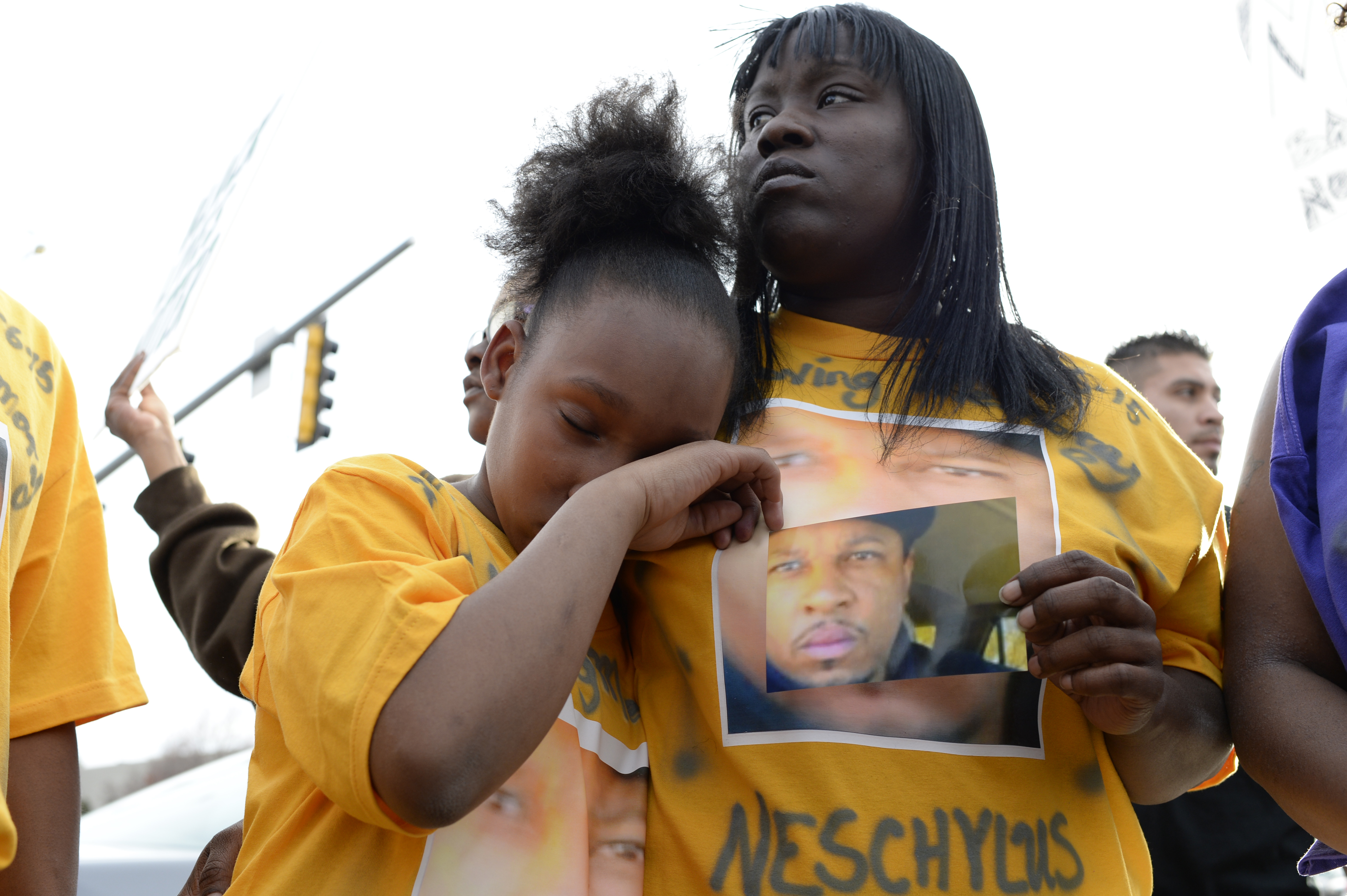 Xiaxong Carter, 10, daughter of Naeschylus Vinzant, wipes away a tear while she holds onto her mother, Laneisha Butler during a protest against the fatal police shooting of her father, in Aurora, Colo. on March 11, 2015.