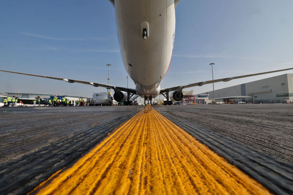 Ground crews prepare an Emirates Boeing 777-300ER aircraft, powering one of its engines with a hundred per cent Sustainable Aviation Fuel on Jan. 30, 2023.
