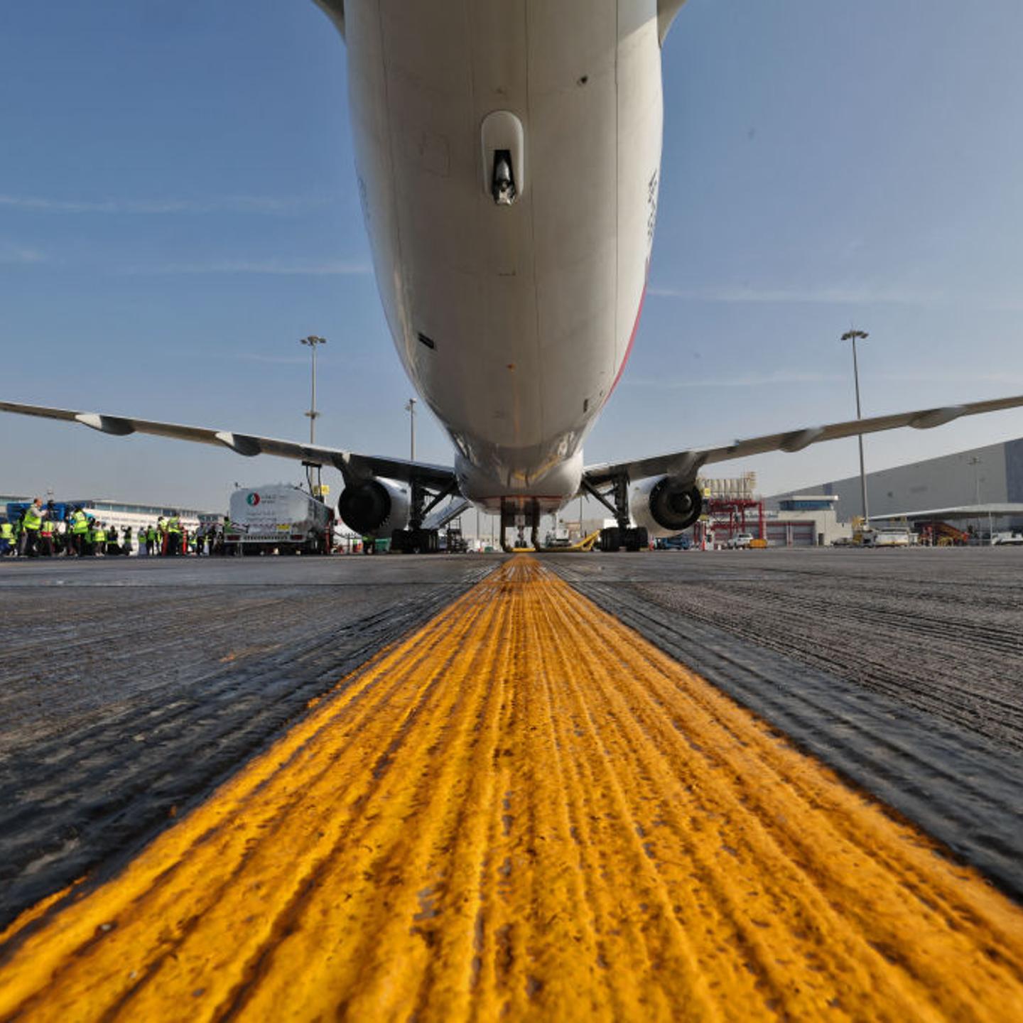 Ground crews prepare an Emirates Boeing 777-300ER aircraft, powering one of its engines with a hundred per cent Sustainable Aviation Fuel on Jan. 30, 2023.