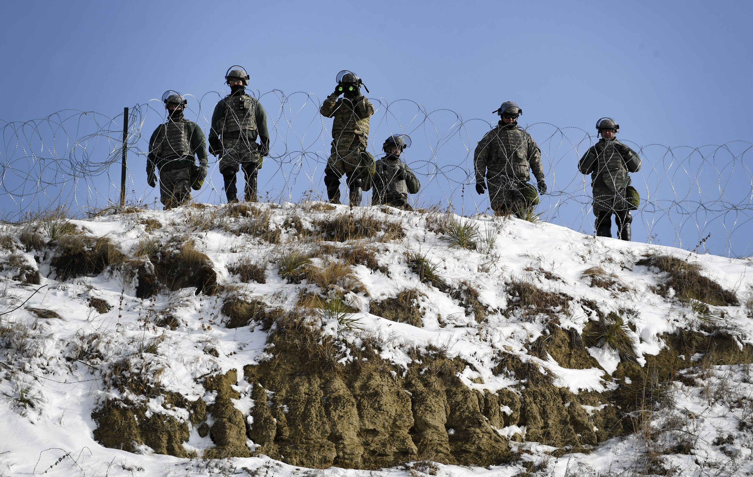 North Dakota national guardsmen stand guard on Turtle Island watching activists and native americans at Oceti Sakowin Camp on the edge of the Standing Rock Sioux Reservation outside Cannon Ball, North Dakota on Dec. 3, 2016.