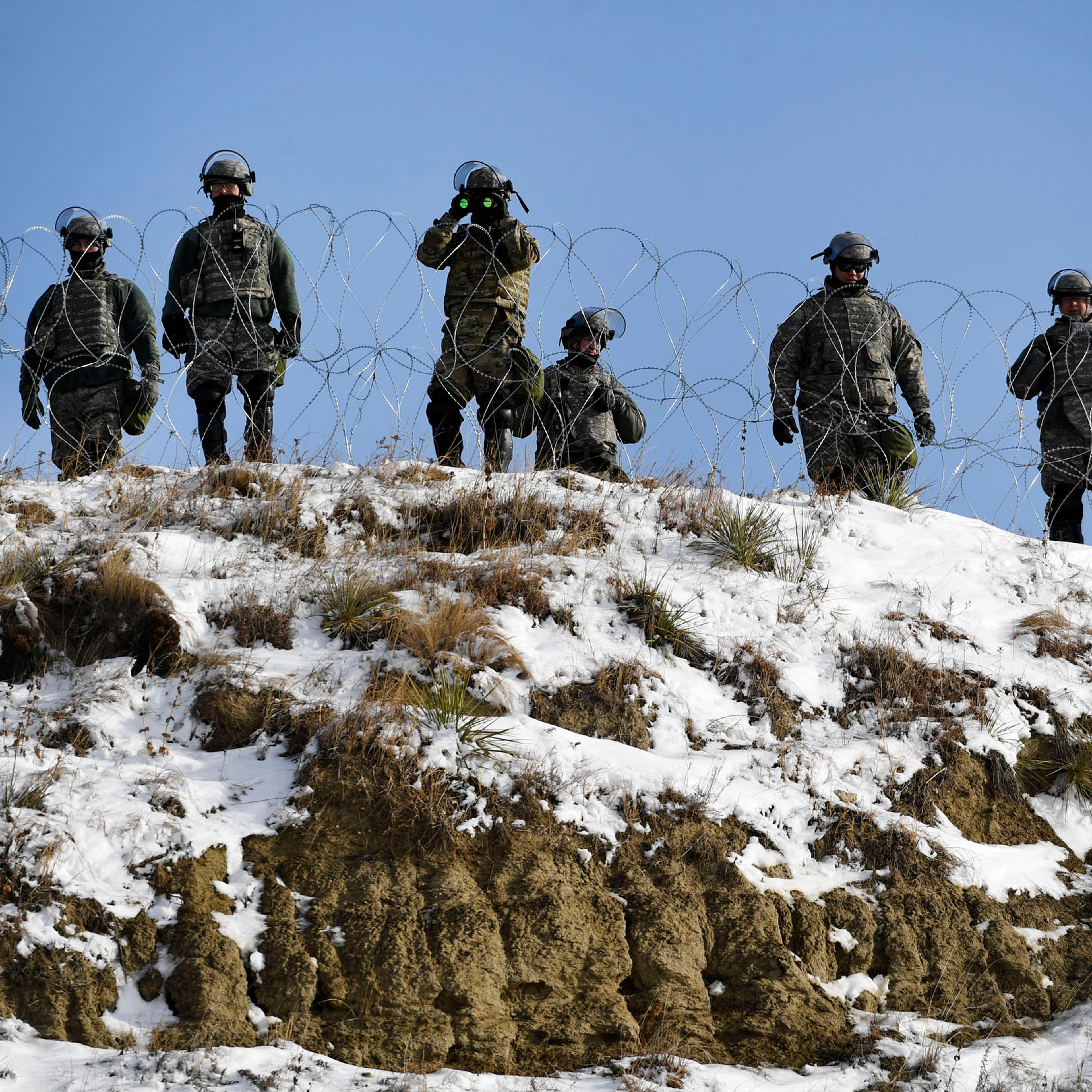 North Dakota national guardsmen stand guard on Turtle Island watching activists and native americans at Oceti Sakowin Camp on the edge of the Standing Rock Sioux Reservation outside Cannon Ball, North Dakota on Dec. 3, 2016.
