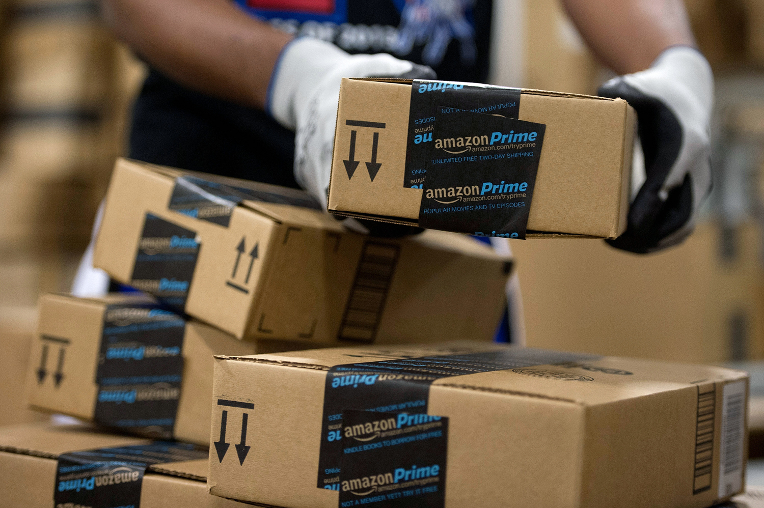 An employee stacks items to be shipped at the Amazon.com Inc. fulfillment center in Phoenix Dec. 1, 2013.
