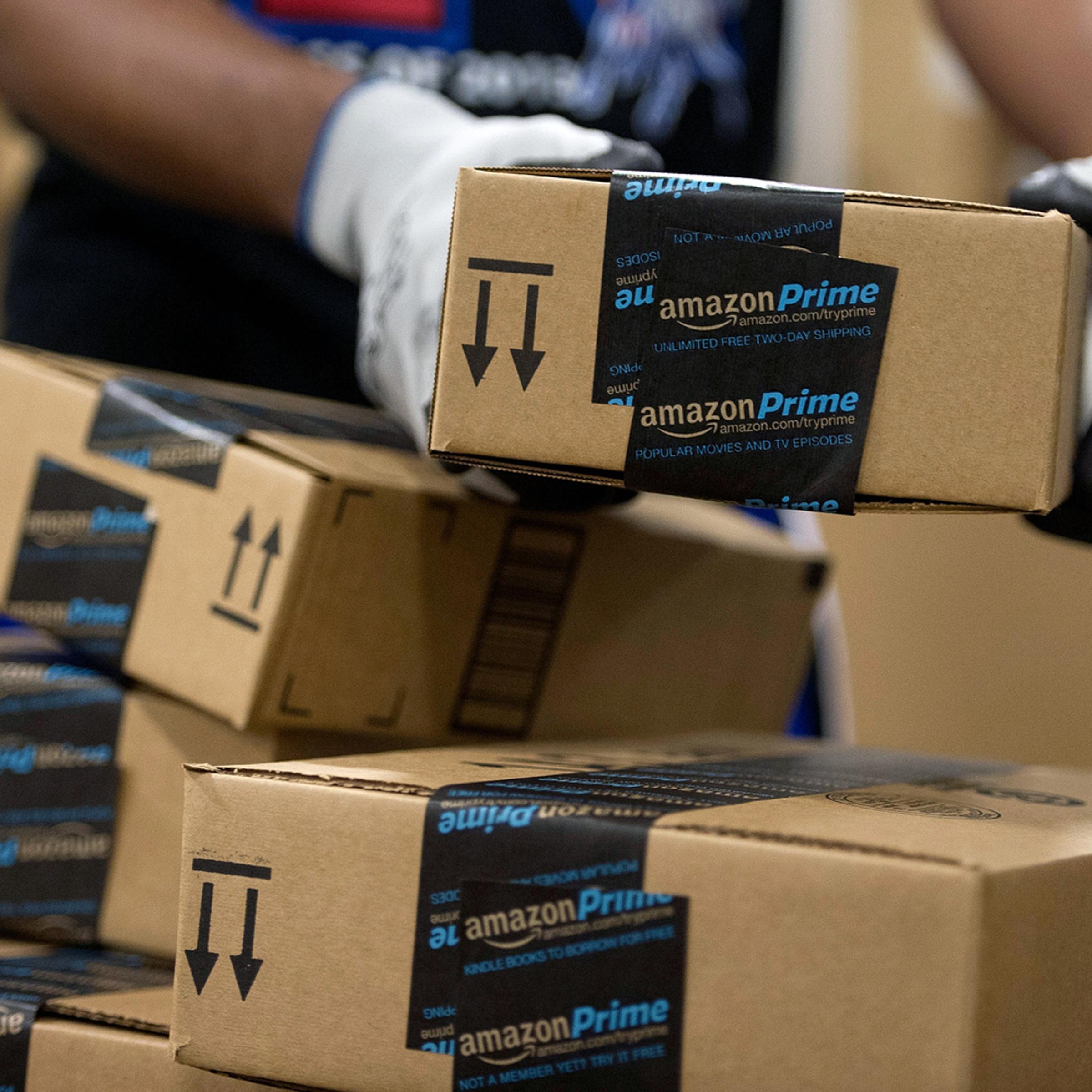An employee stacks items to be shipped at the Amazon.com Inc. fulfillment center in Phoenix Dec. 1, 2013.