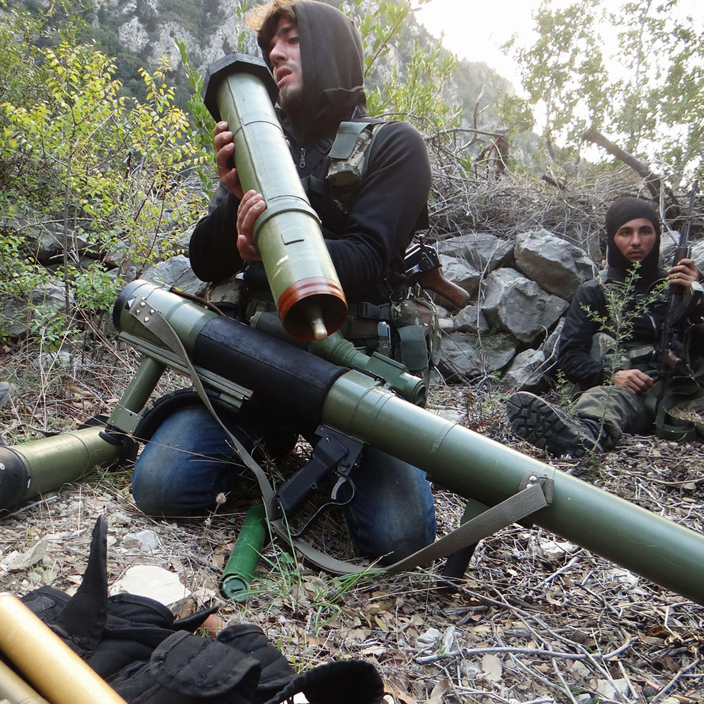 A rebel fighter checks a launcher near the village of Kessab and the border crossing with Turkey, in the northwestern province of Latakia, on March 23, 2014. Rebels seized Kessab a day later.