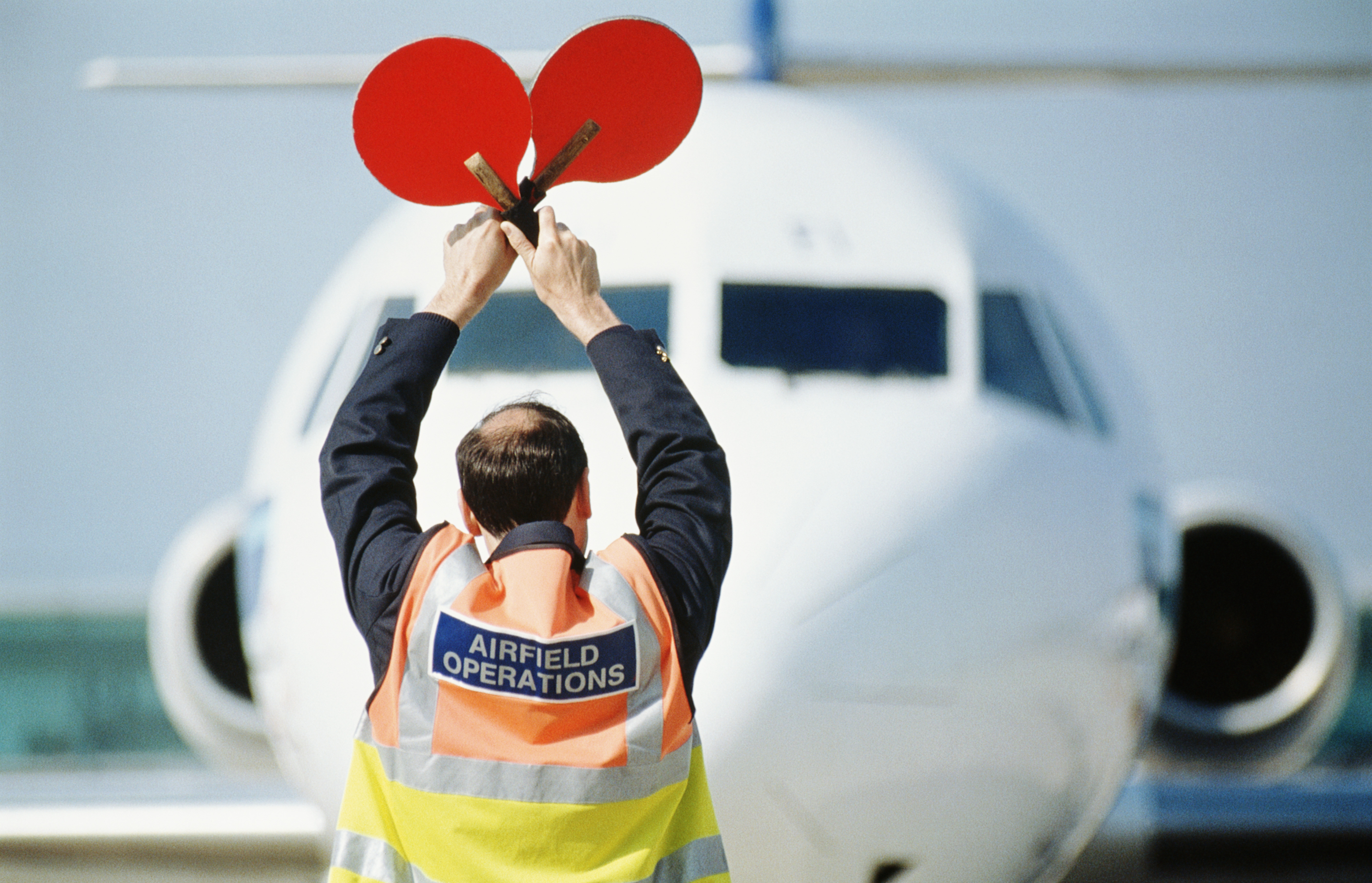 airport-ground-crew-signaling-airplane