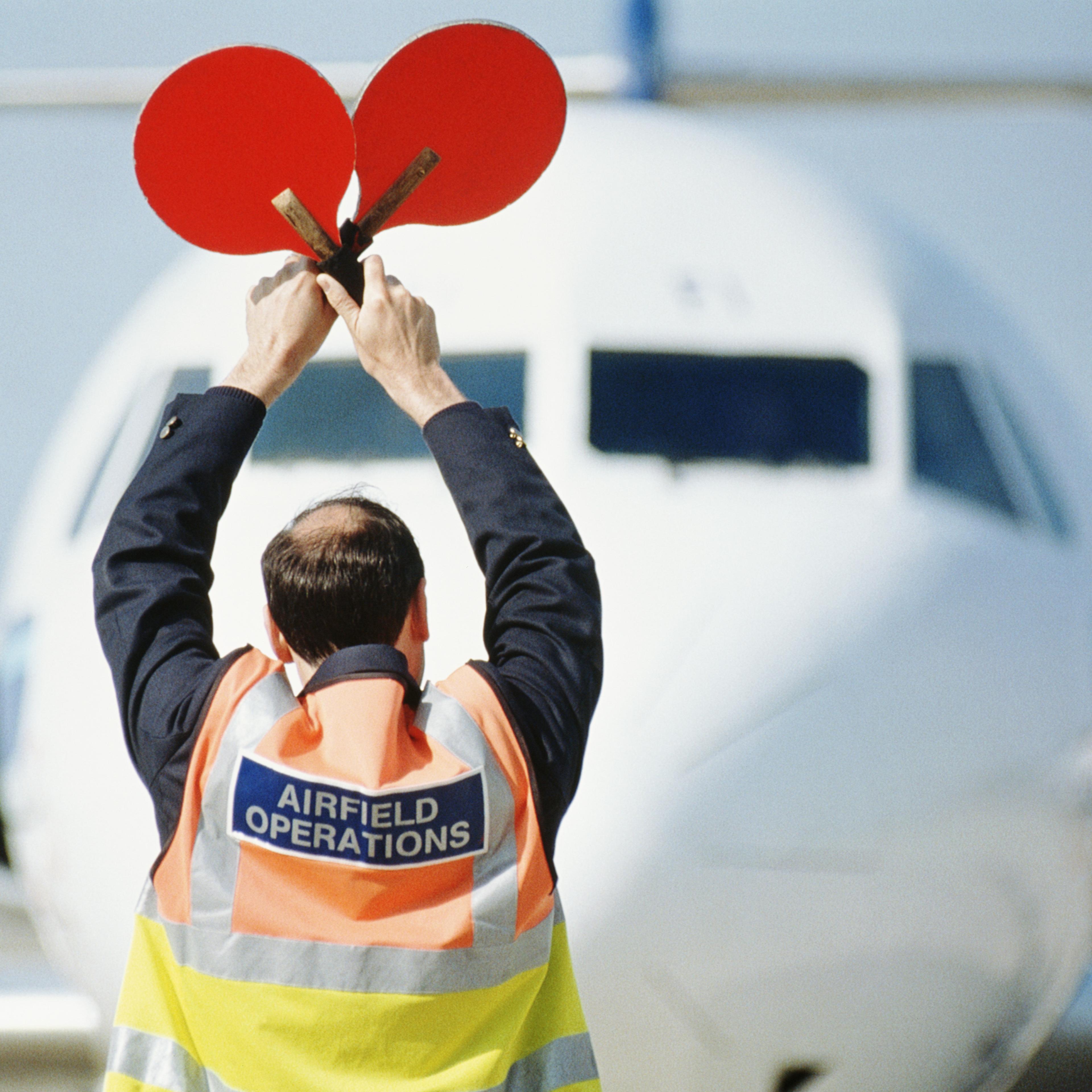 airport-ground-crew-signaling-airplane