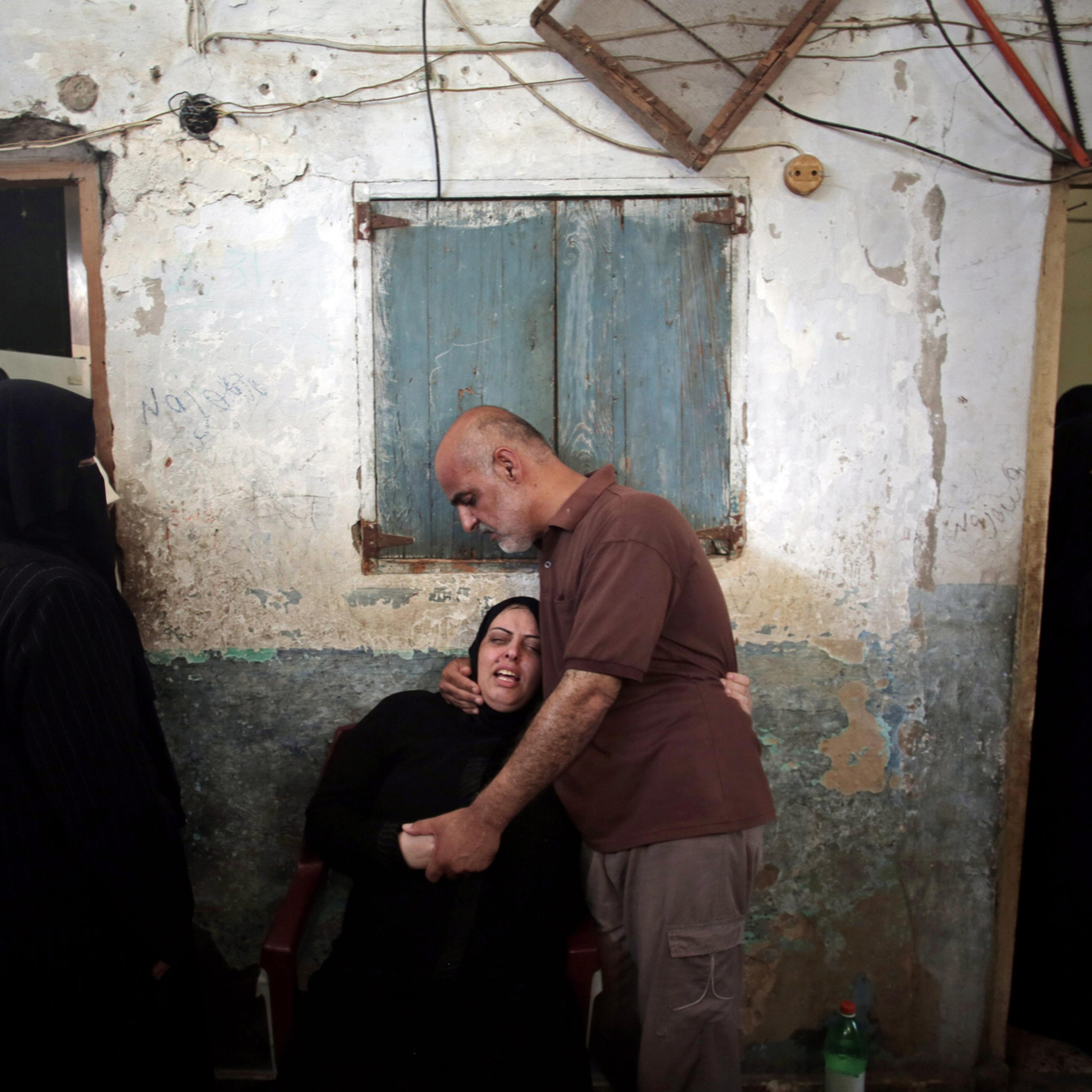 Palestinian relatives of eight members of the Al Haj family, who were killed in a strike early morning, grieve in the family house during their funeral in Khan Younis refugee camp, southern Gaza Strip on Thursday, July 10, 2014.
