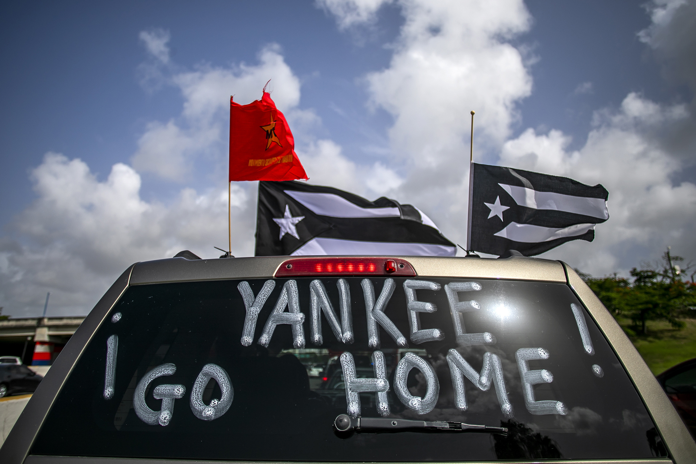 "Yankee Go Home" is displayed on a vehicle during a protest against U.S. mainland tourist arriving from coronavirus hot zones outside Luis Munoz Airport in San Juan, Puerto Rico, on July 25, 2020.