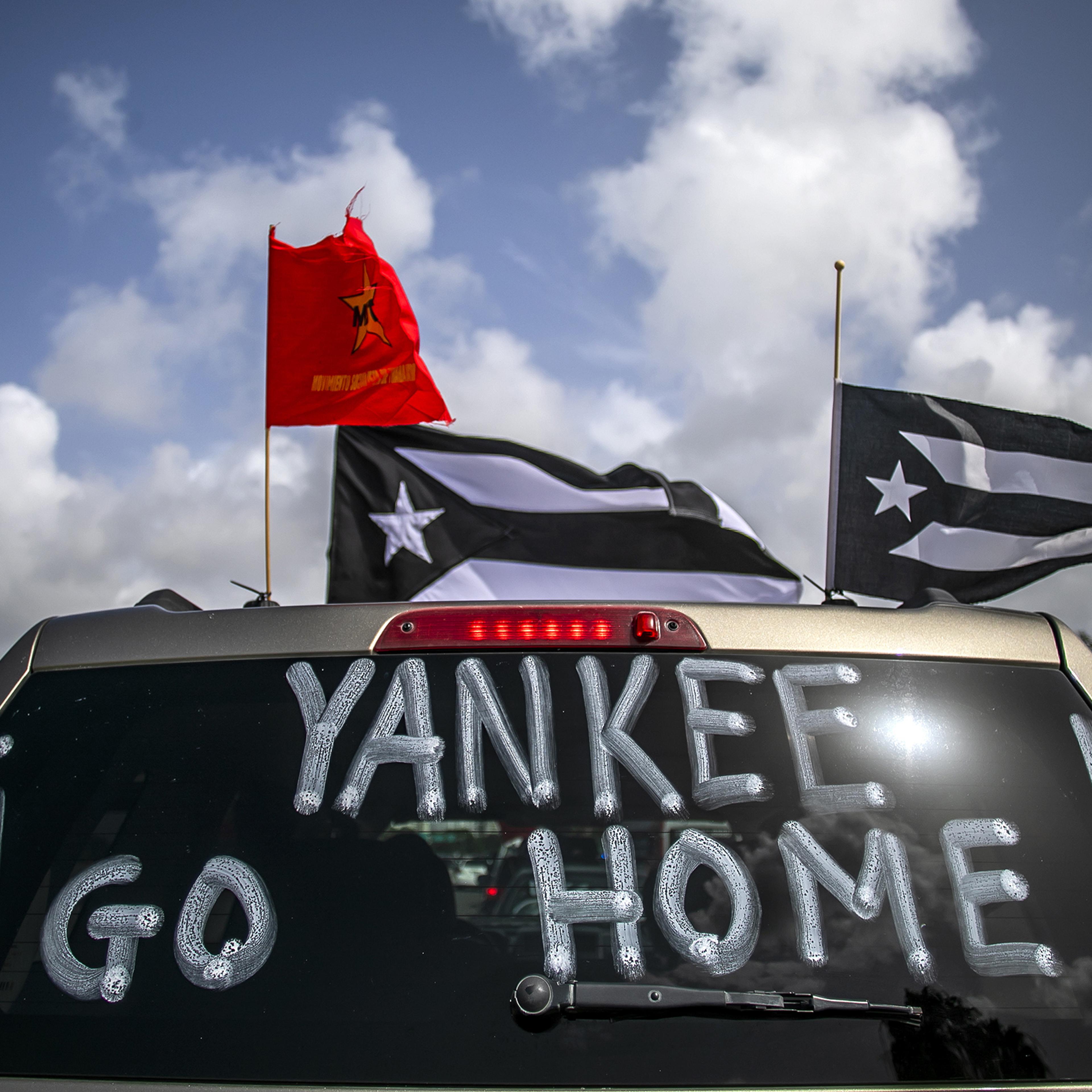 "Yankee Go Home" is displayed on a vehicle during a protest against U.S. mainland tourist arriving from coronavirus hot zones outside Luis Munoz Airport in San Juan, Puerto Rico, on July 25, 2020.