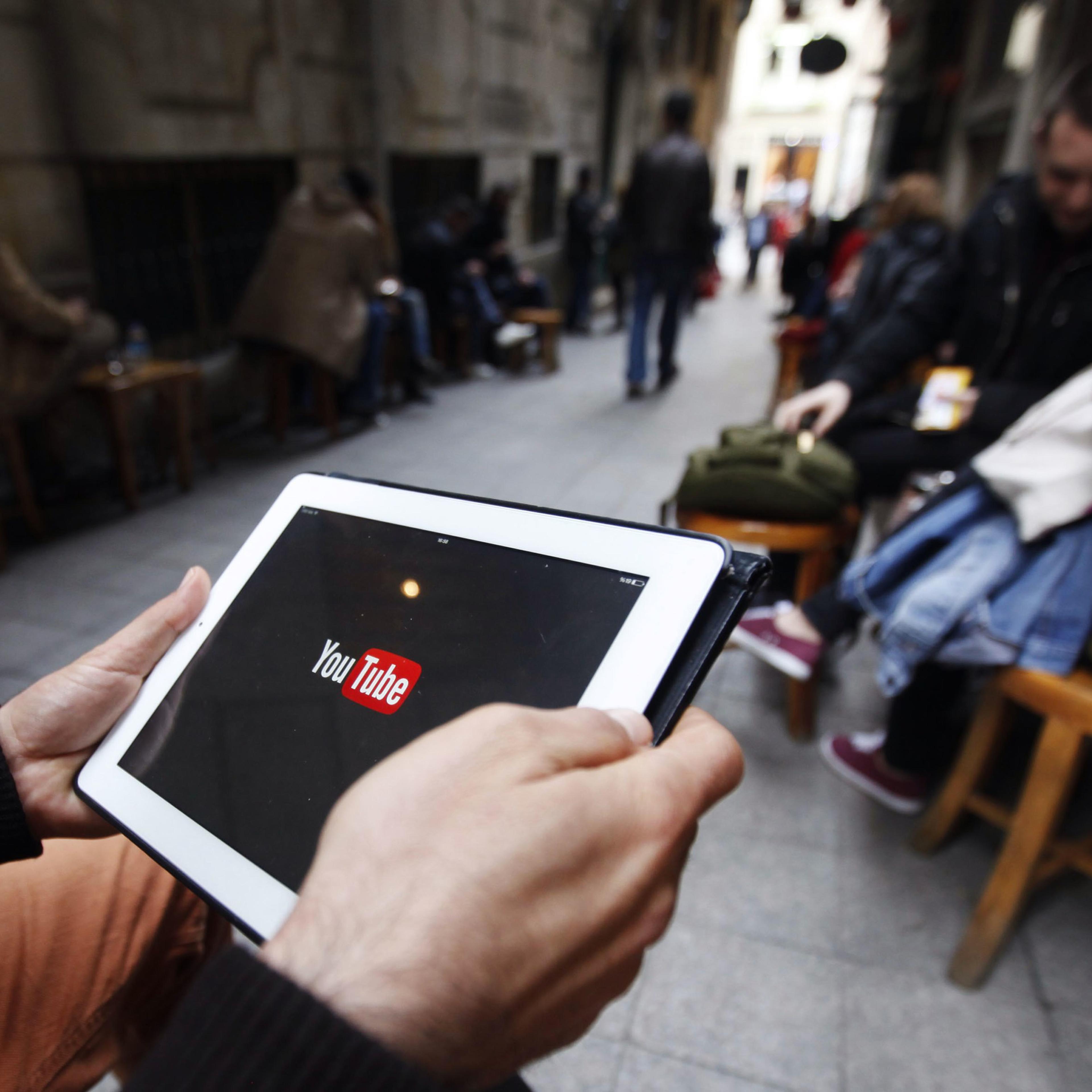 A man tries to get connected to the youtube web site with his tablet at a cafe in Istanbul