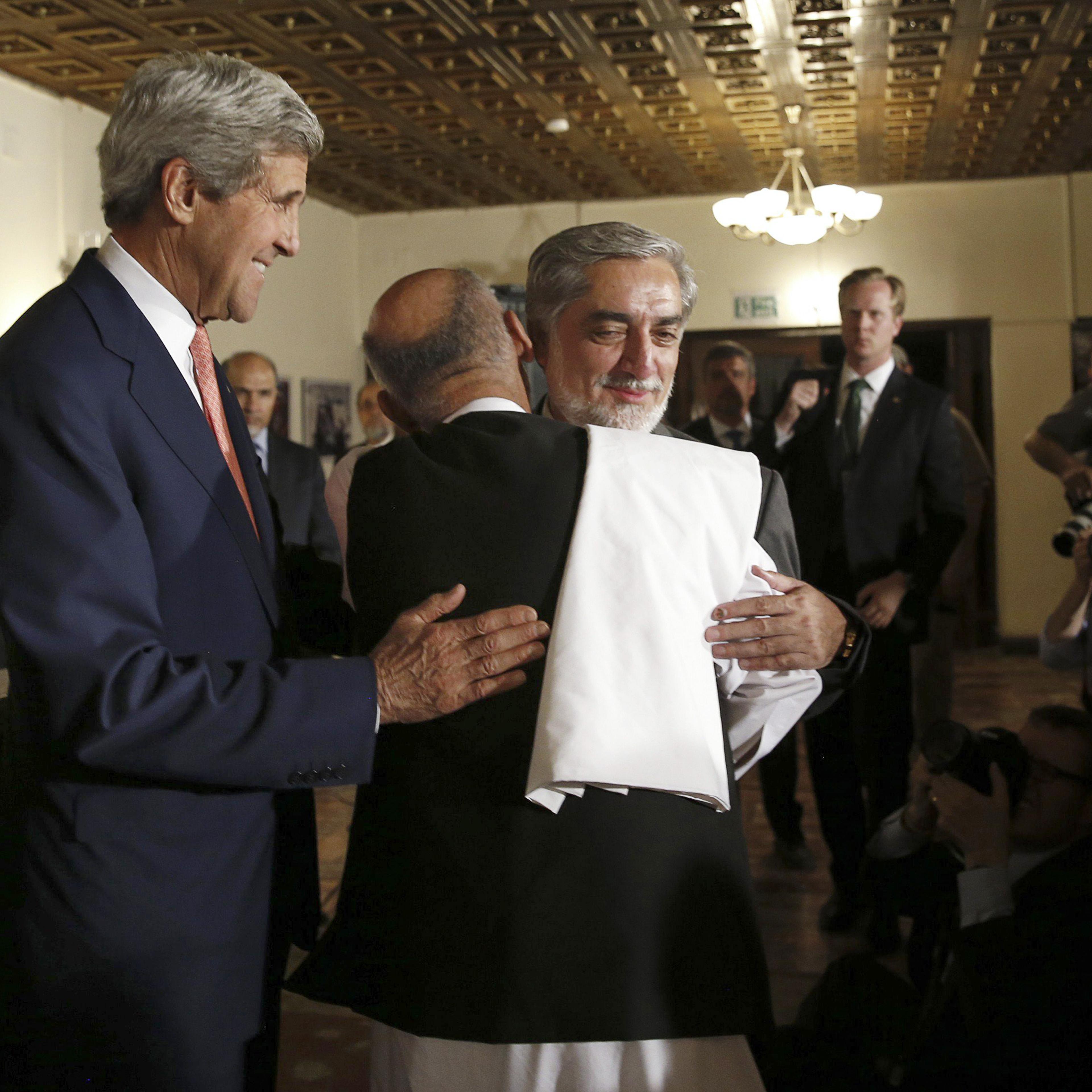 Presidential candidates Abdullah Abdullah, right, and Ashraf Ghani embrace at a news conference with Secretary of State John Kerry where a deal to audit ballots was announced, in Kabul, Afghanistan on July 12, 2014.