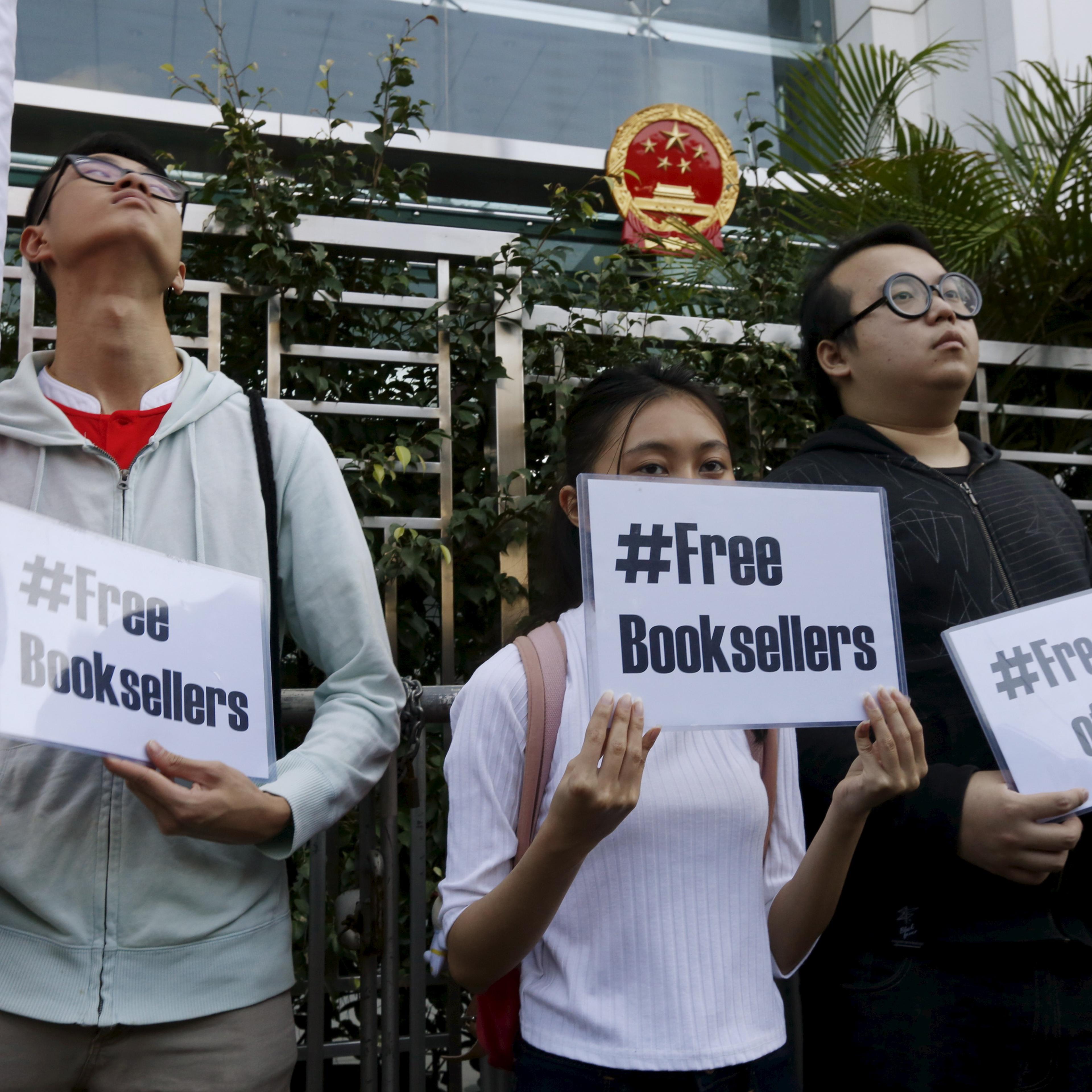 Members of student group Scholarism hold up placards during a protest about the disappearances of booksellers outside China's liaison office in Hong Kong, China