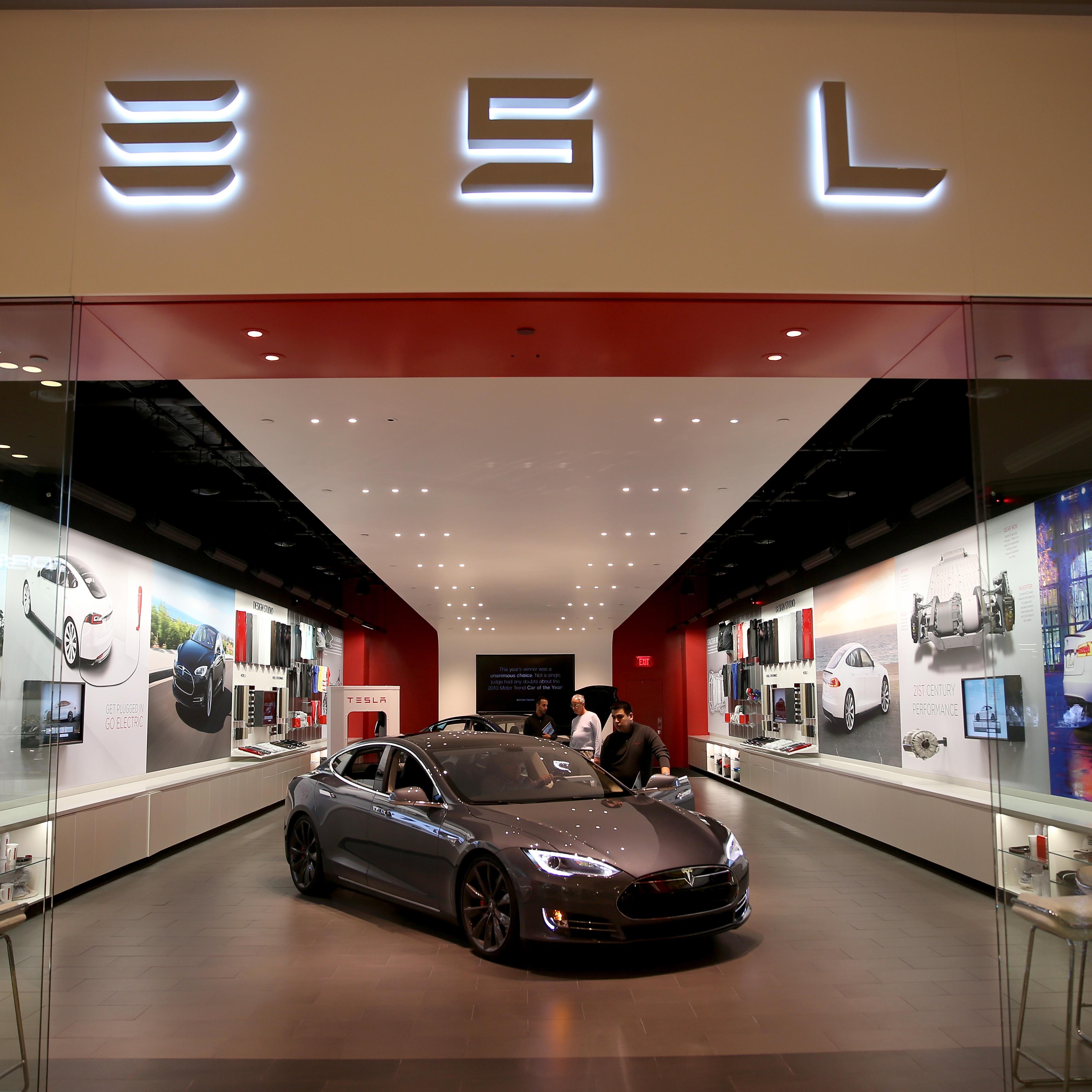 People look at a Tesla Motors vehicle on the showroom floor at the Dadeland Mall on February 19, 2014 in Miami, Florida.