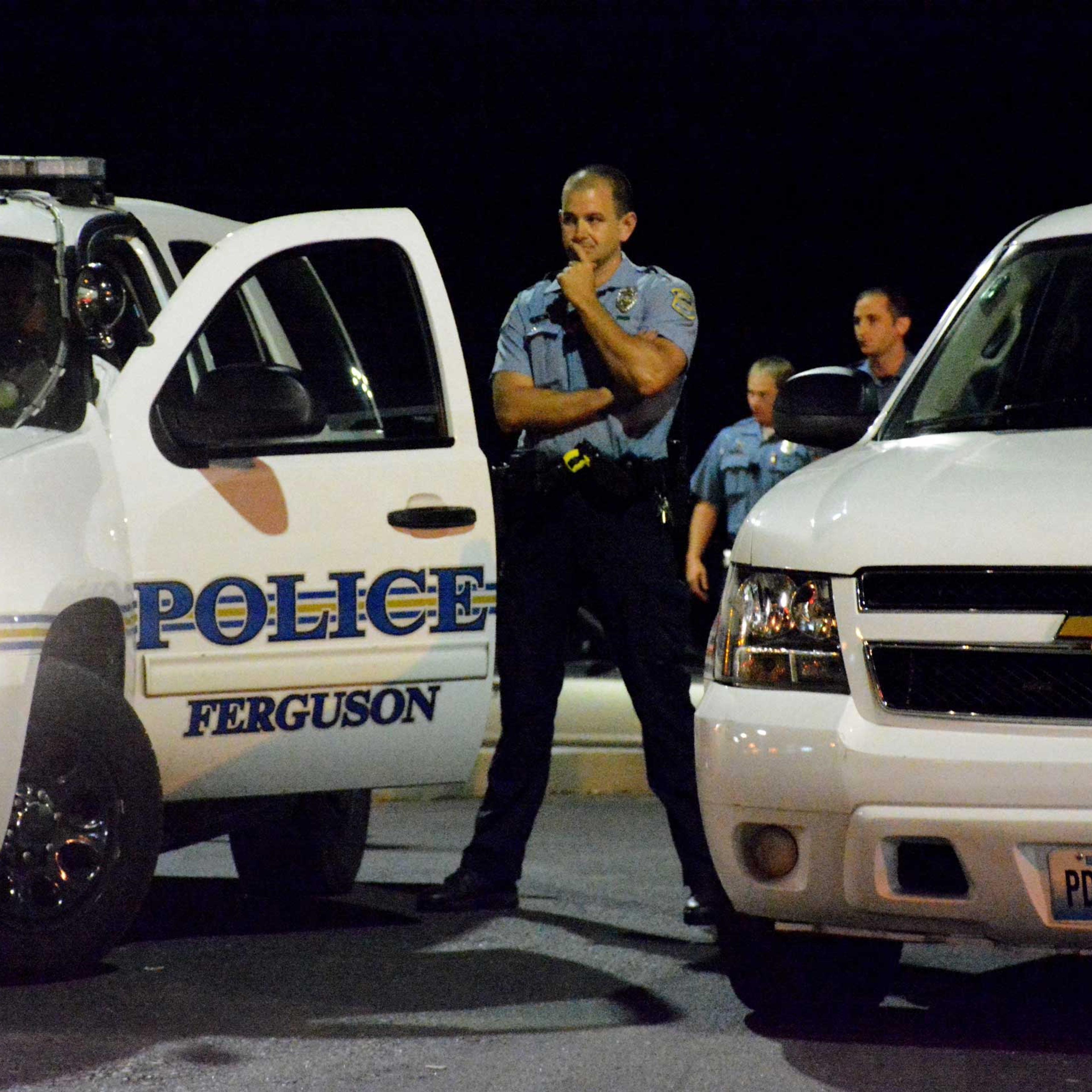 A police officer observes the crowd gathered in protest the police shooting of teenager Mike Brown, Ferguson, Missouri, Sept. 29, 2014.
