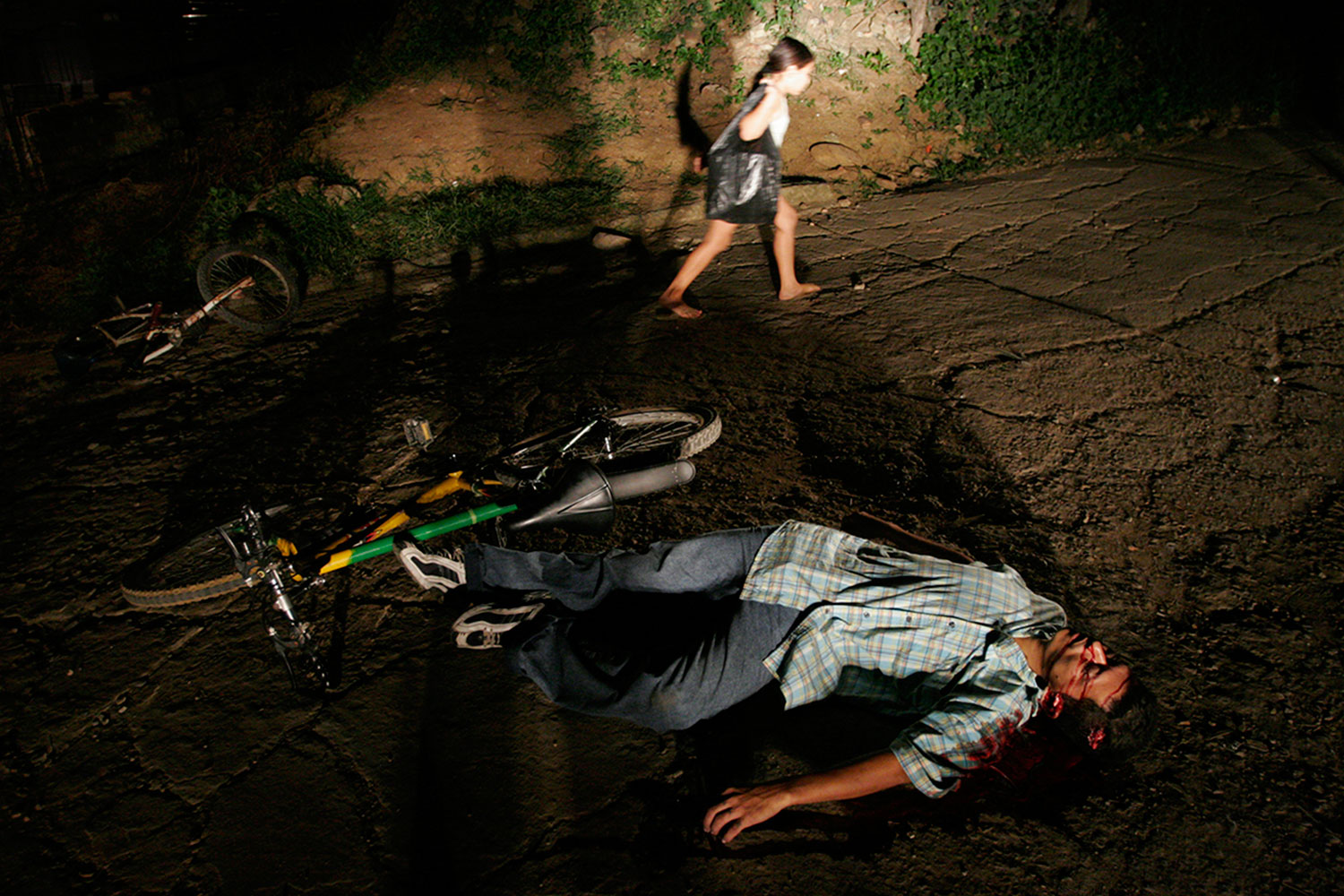 A young girl passes the body of a man assassinated in Cucuta, Colombia