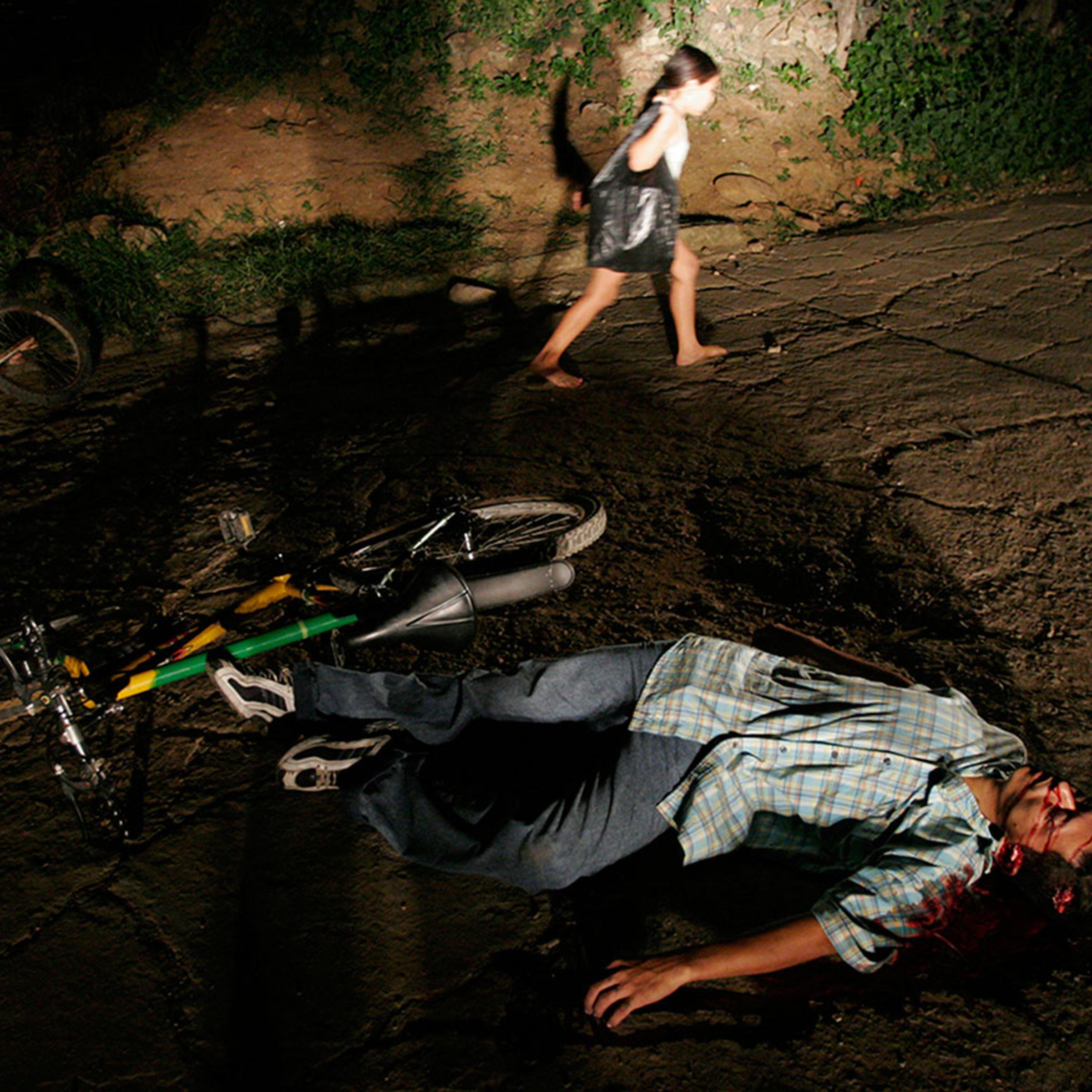 A young girl passes the body of a man assassinated in Cucuta, Colombia