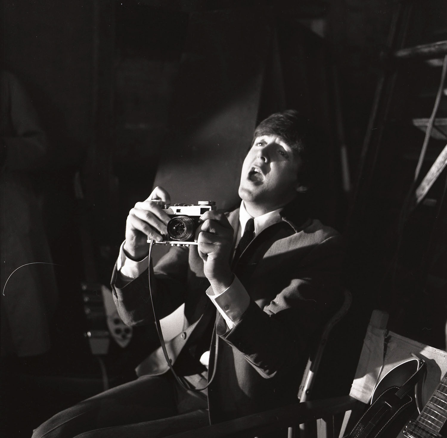 Paul McCartney on the set of 'A Hard Day's Night' at the Scala Theater, holding camera. London, England, 1964.