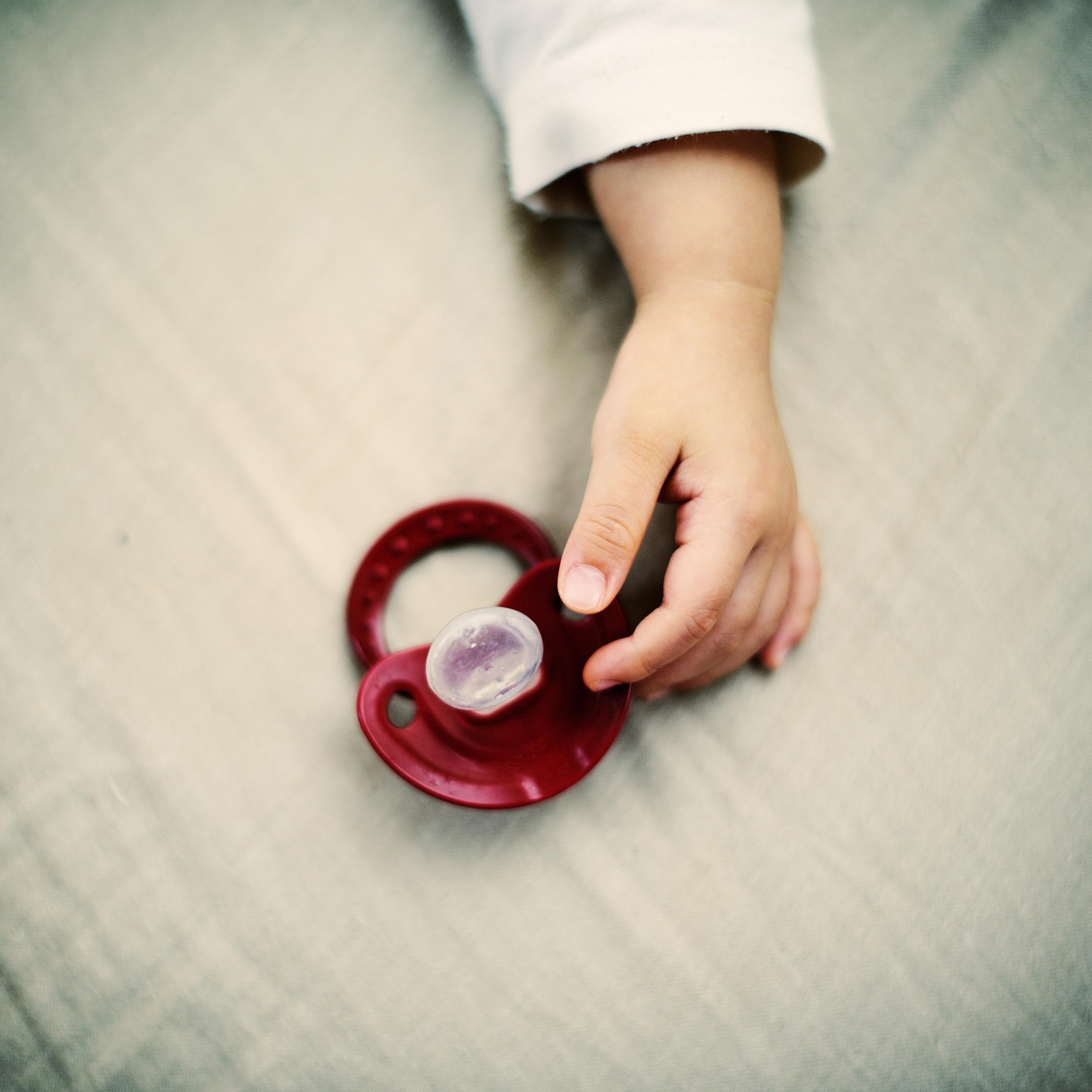 A portrait of a baby's hand with a pacifier